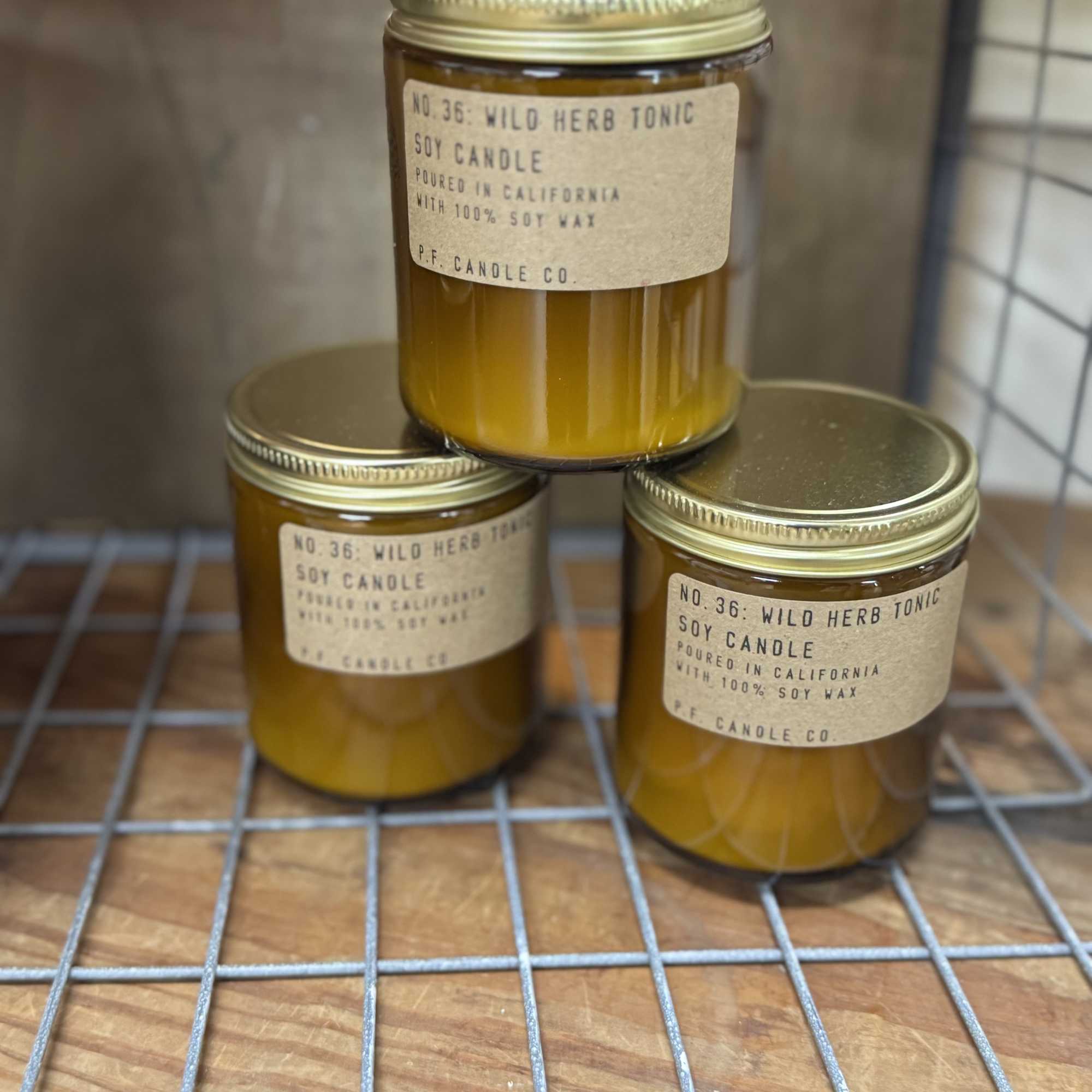 Three amber soy candles in glass jars with gold lids