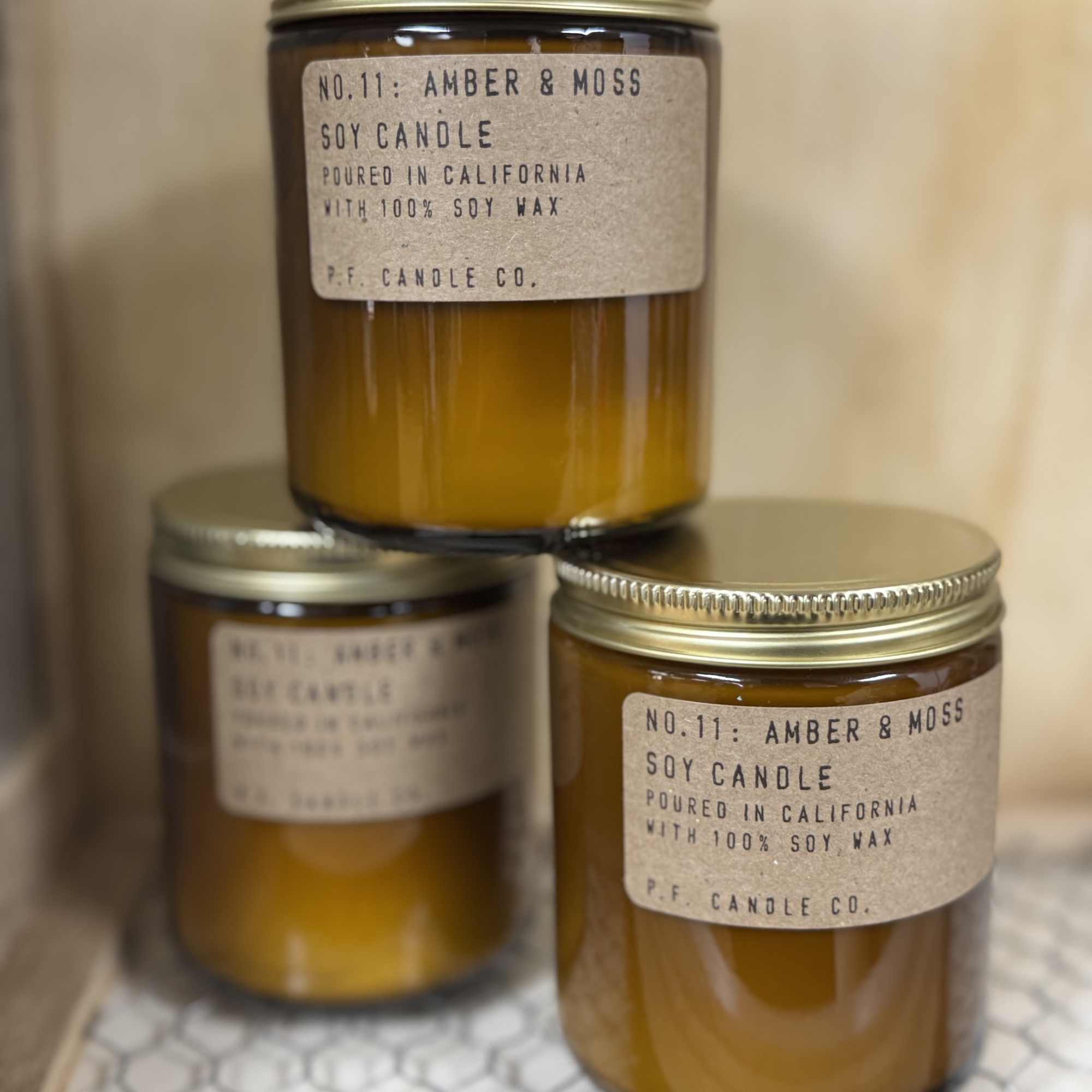 Three amber soy candles in glass jars with metal lids