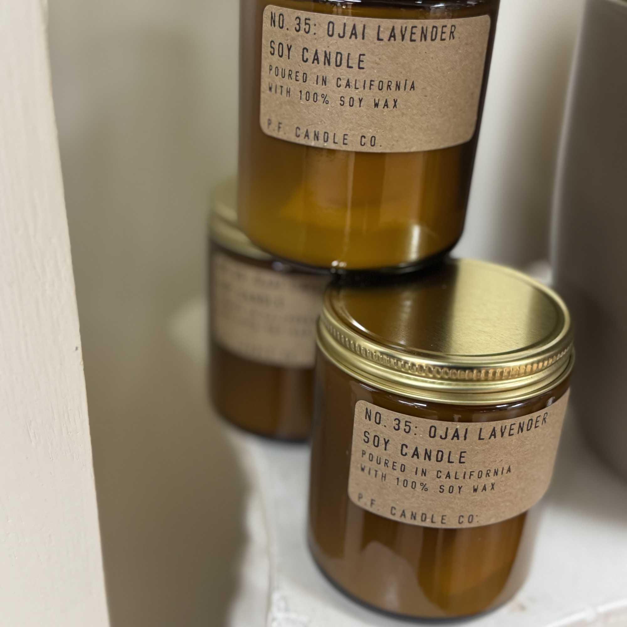 Two amber jar candles with gold lids and lavender labels