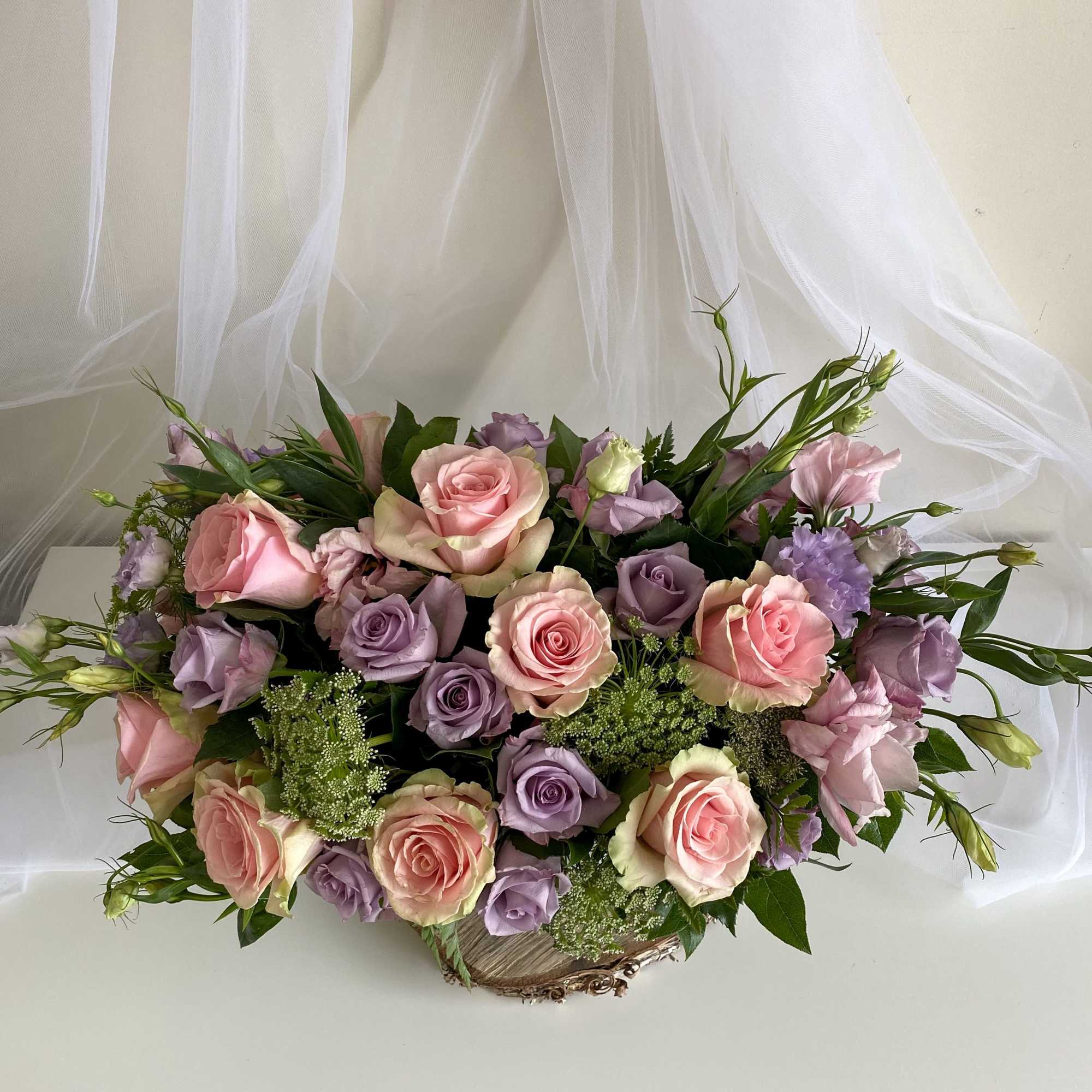 Arrangement of pink and lavender roses in a low basket