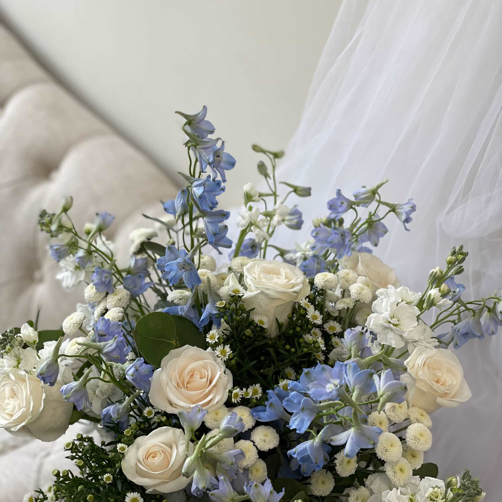 Bouquet of white roses and blue delphinium with small white filler flowers