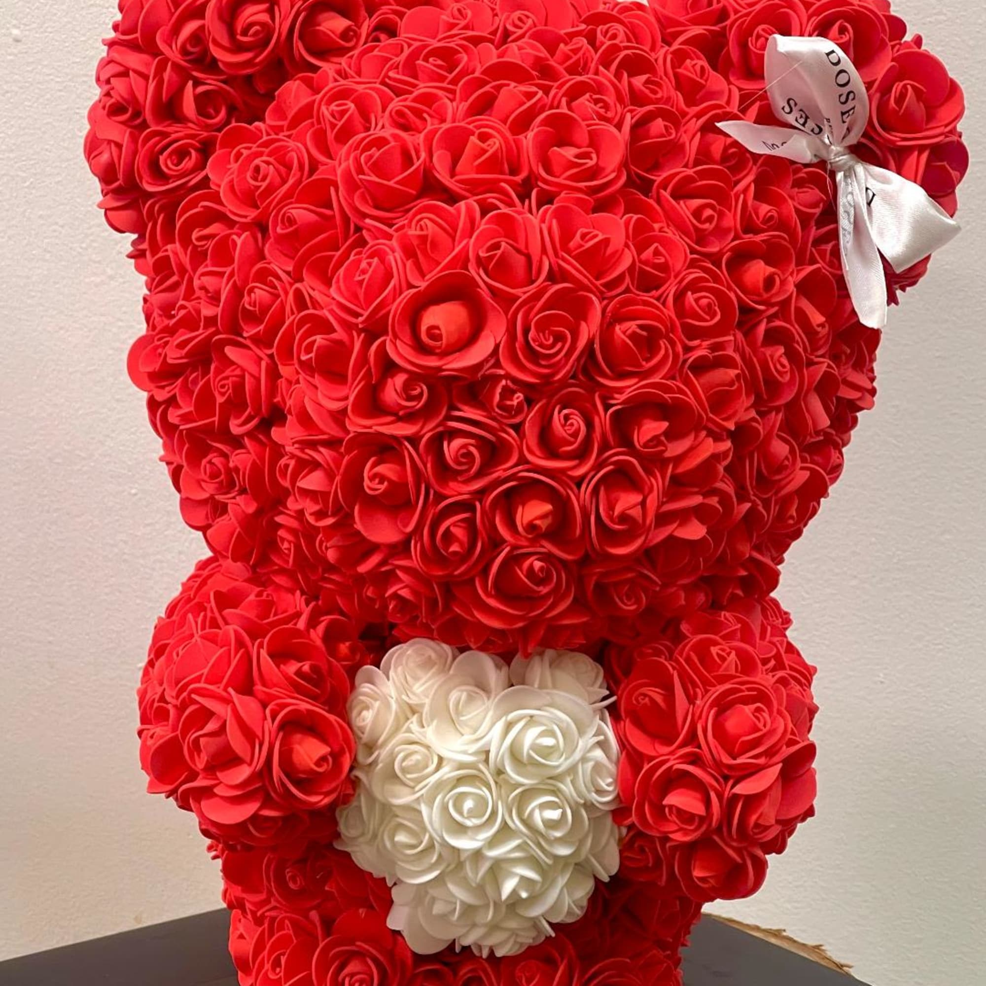 Red teddy bear made of roses with a white rose heart on its chest