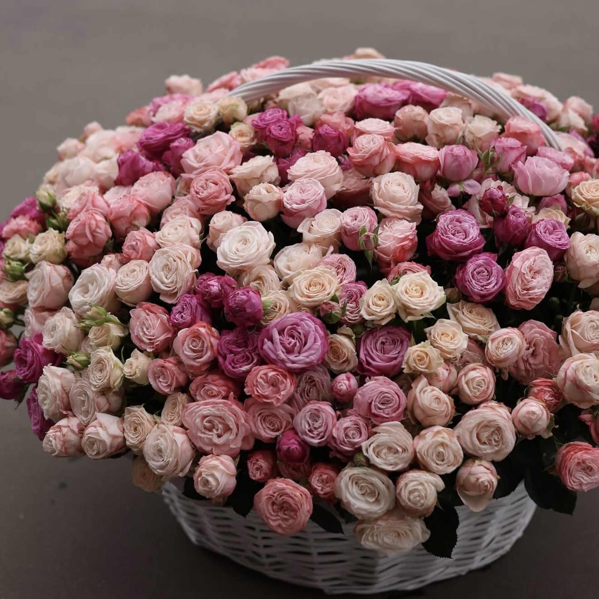 The Rosy Charm Basket is a delicate arrangement of fresh spray roses