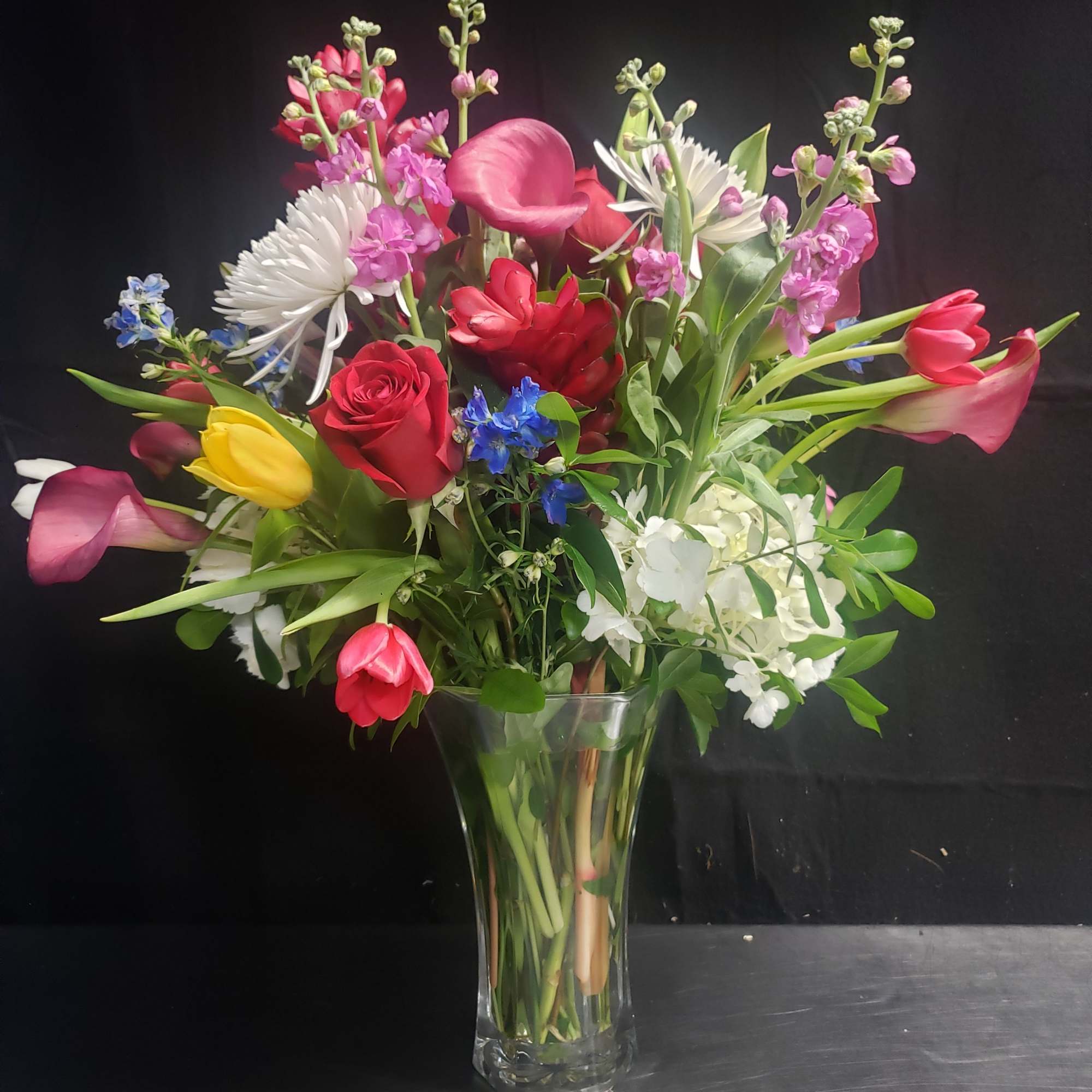 A lively, garden-style flower arrangement that brings a burst of color and