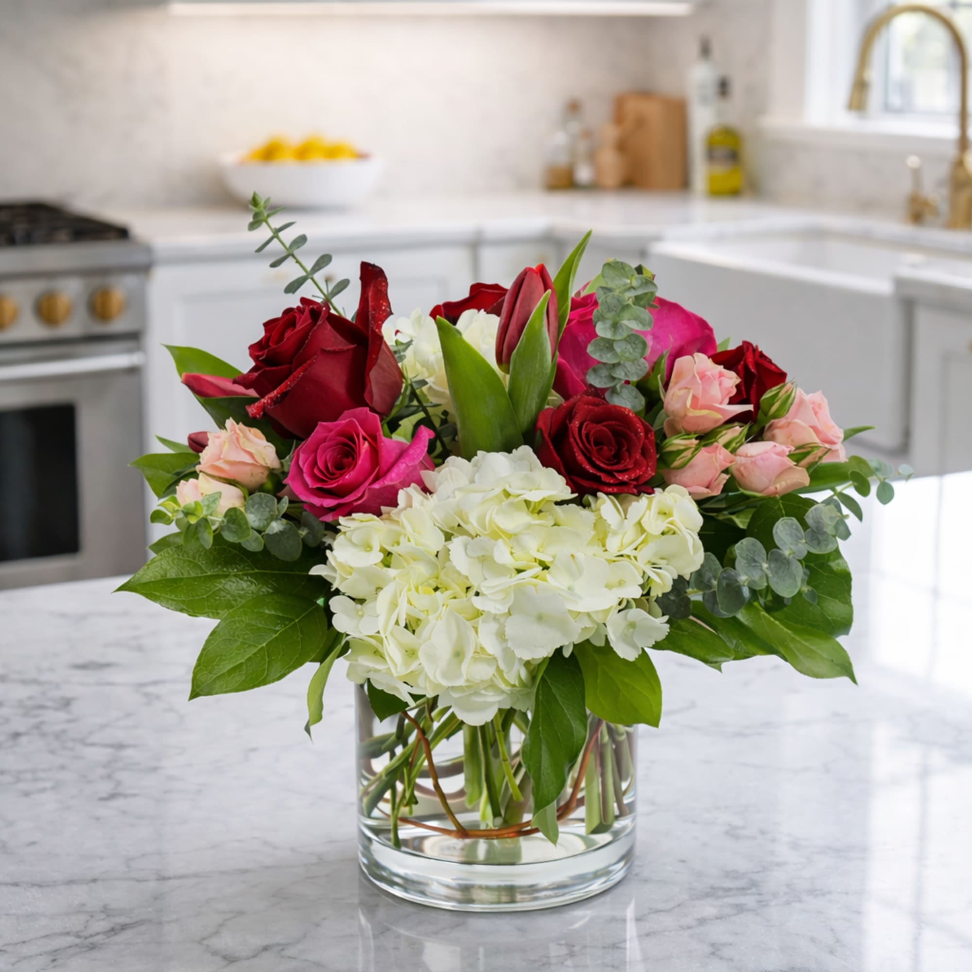 Mixed rose bouquet with white hydrangea in a clear glass vase