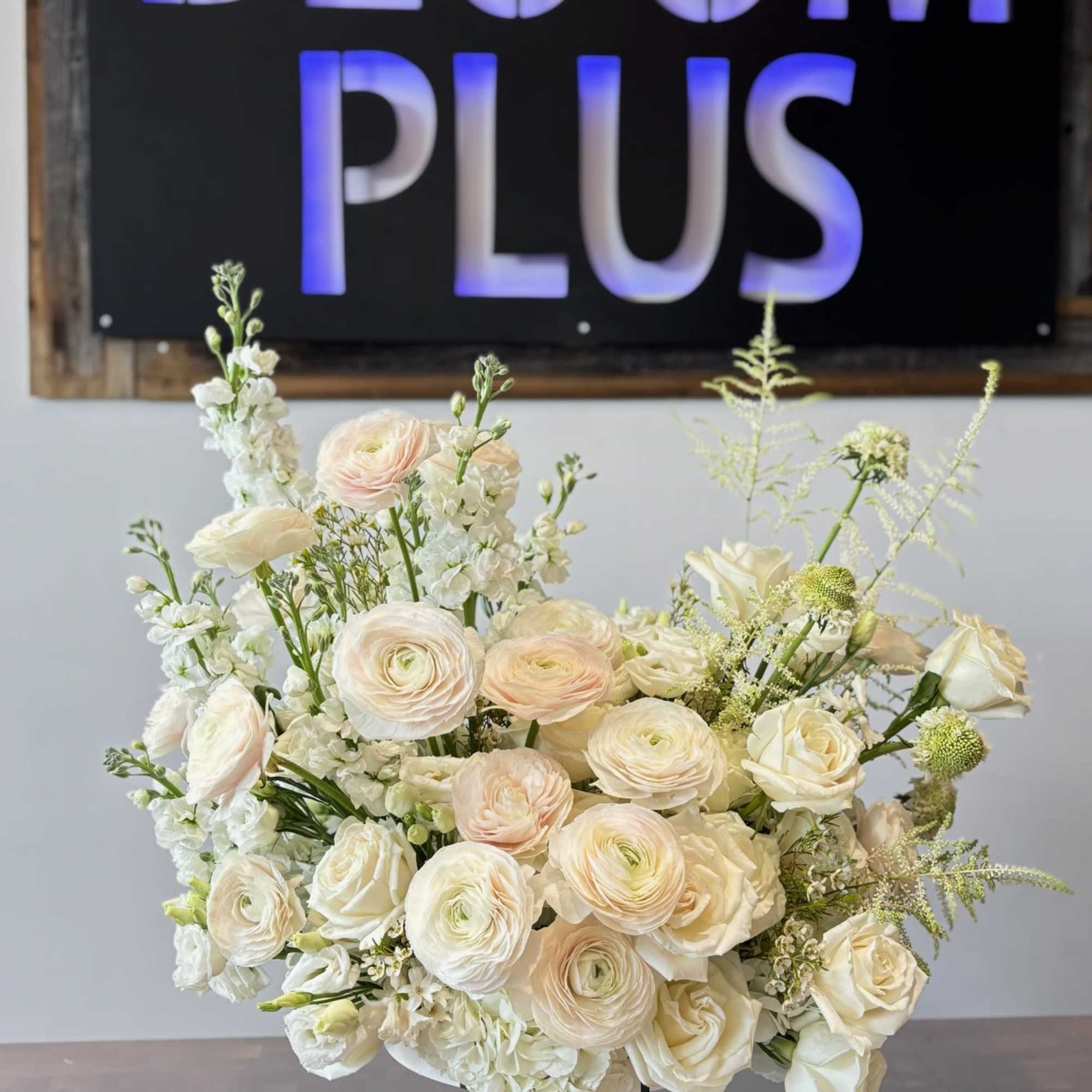 Creamy white floral arrangement in a low white vase