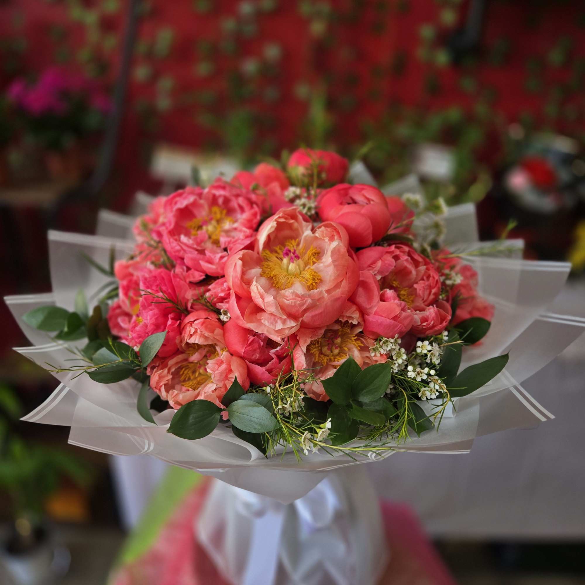 A lush cluster of layered coral peonies creates an immediate "wow"-perfect as