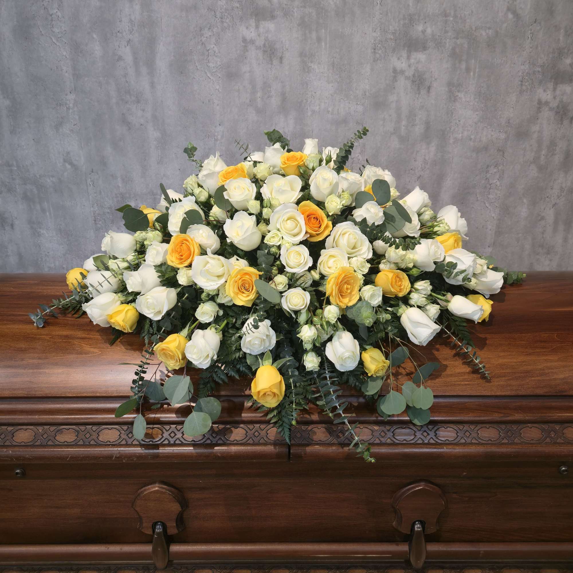 A gorgeous casket spray of white and pink roses.