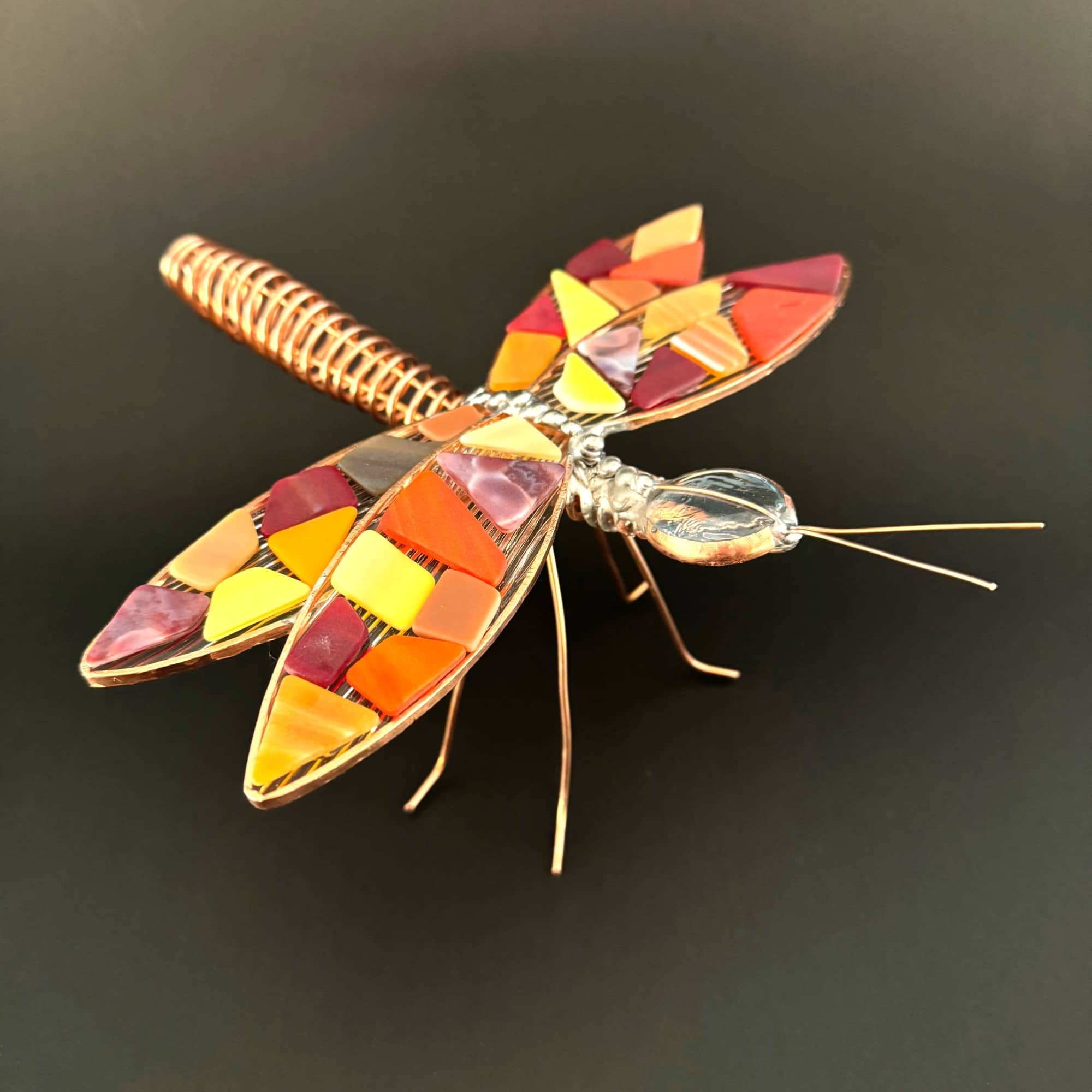 A playful, handcrafted dragonfly accent that brings warm, autumnal color to any