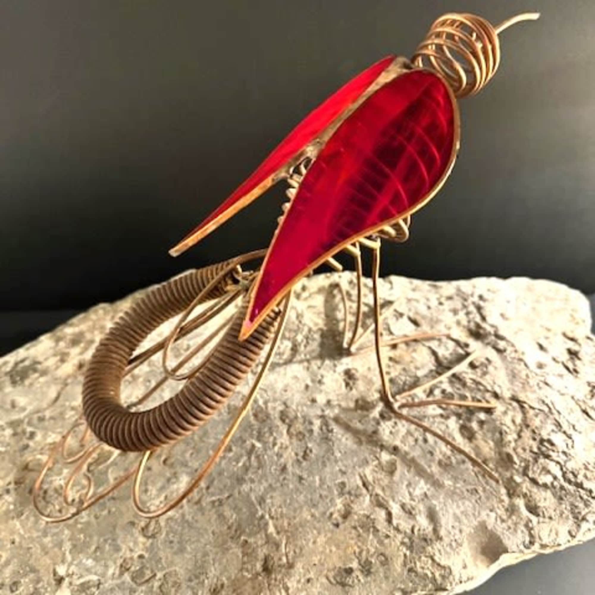 A bold sculptural flourish, this unique standing sculpture features a metal and