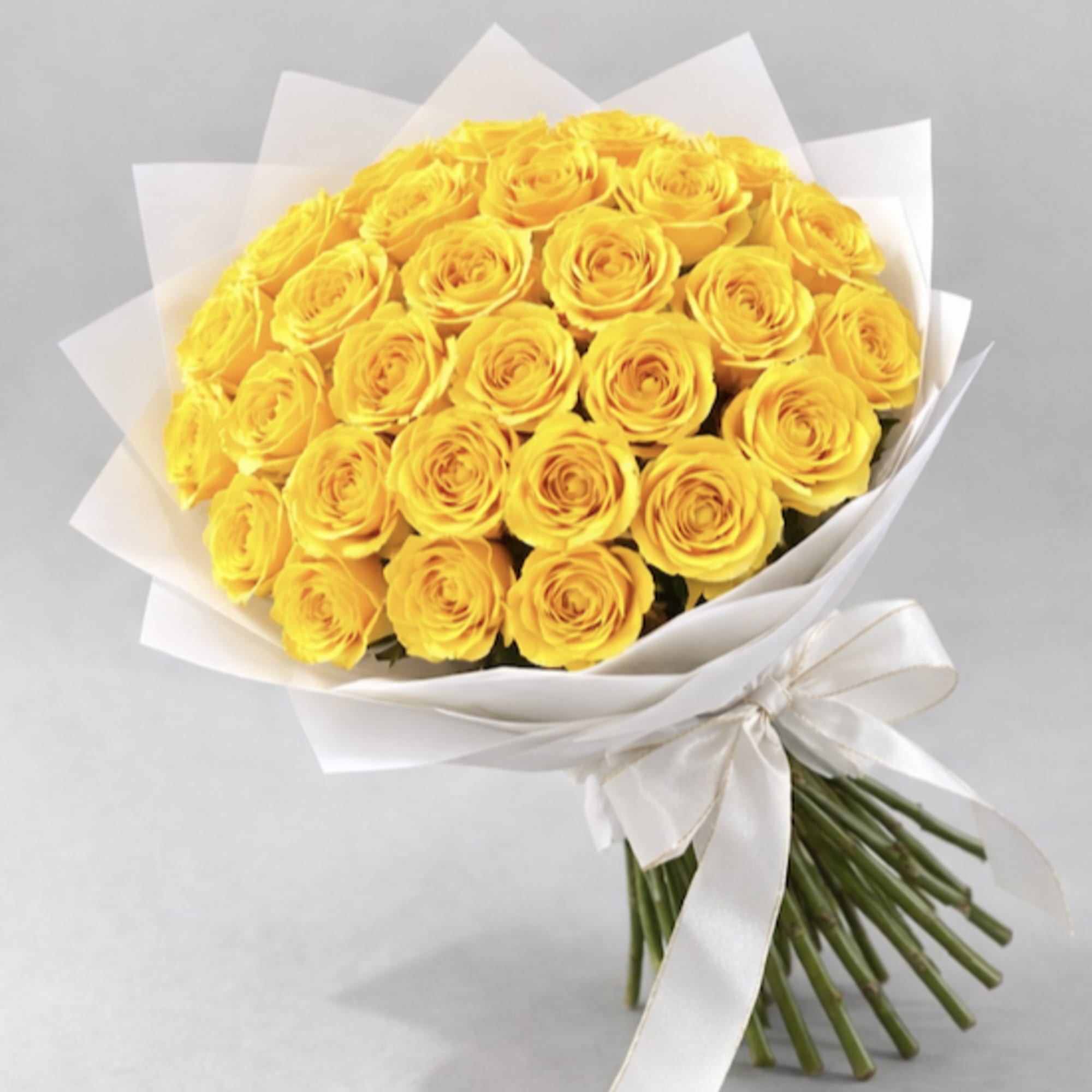 Bouquet of yellow roses wrapped in white paper with a ribbon