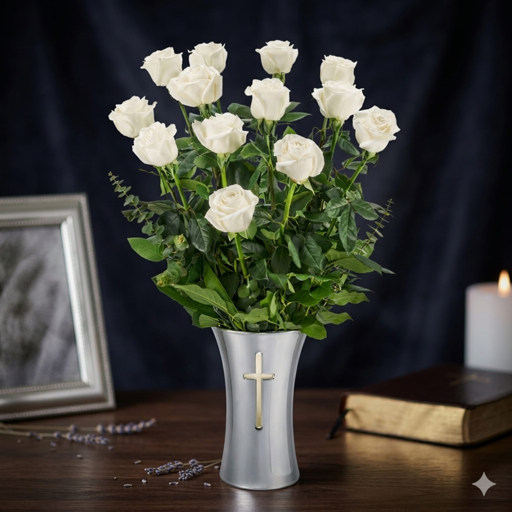 A cluster of pristine white roses rises from a tall silver vase