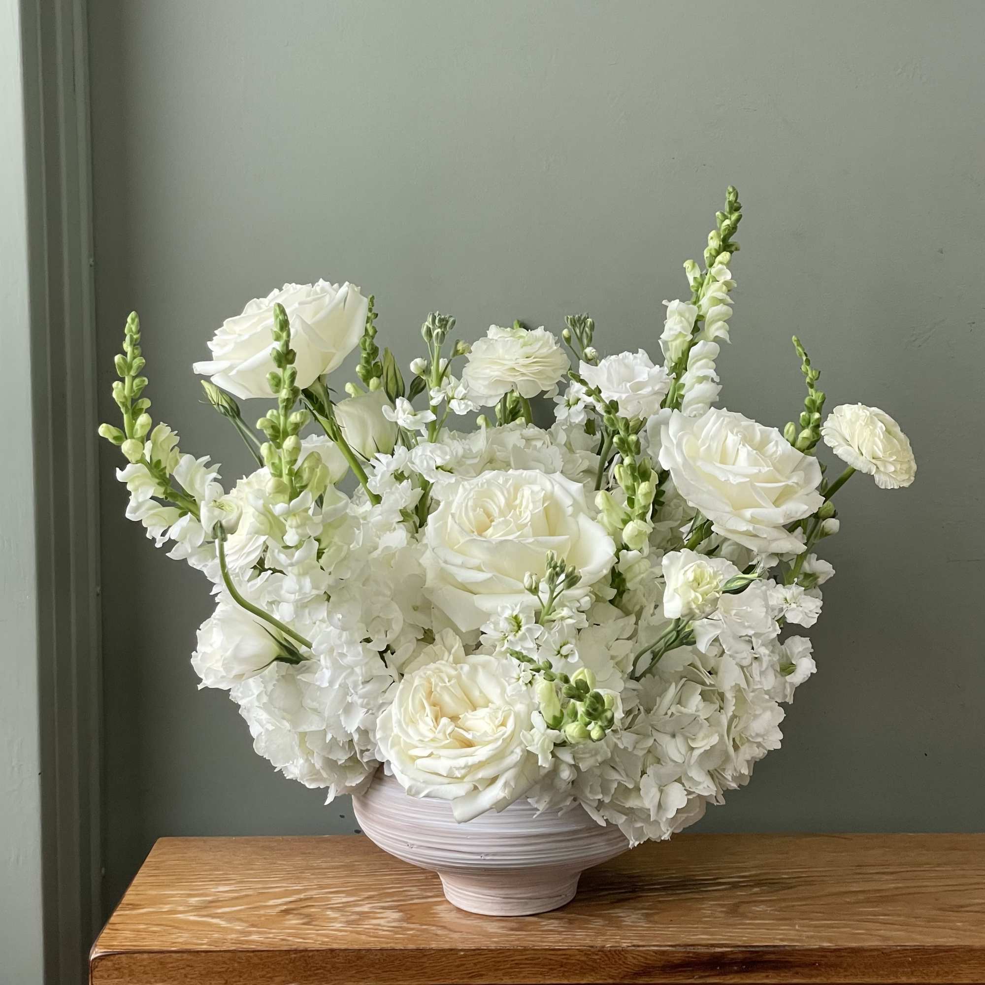 A lush garden of crisp white blooms, thoughtfully arranged with hydrangea, roses