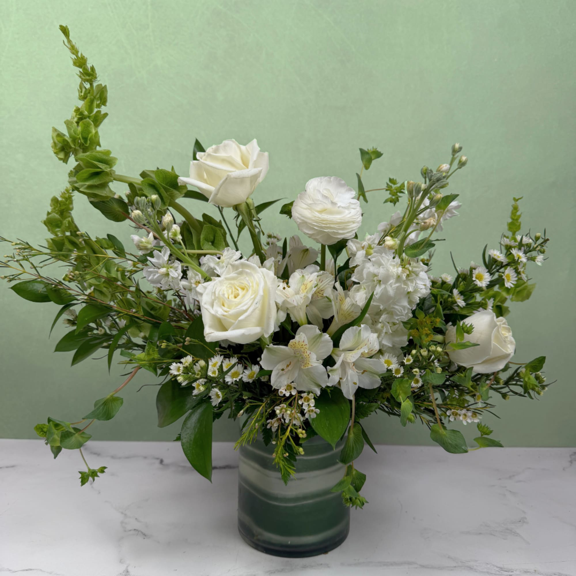 A crisp and elegant mix of white and green blooms designed to
