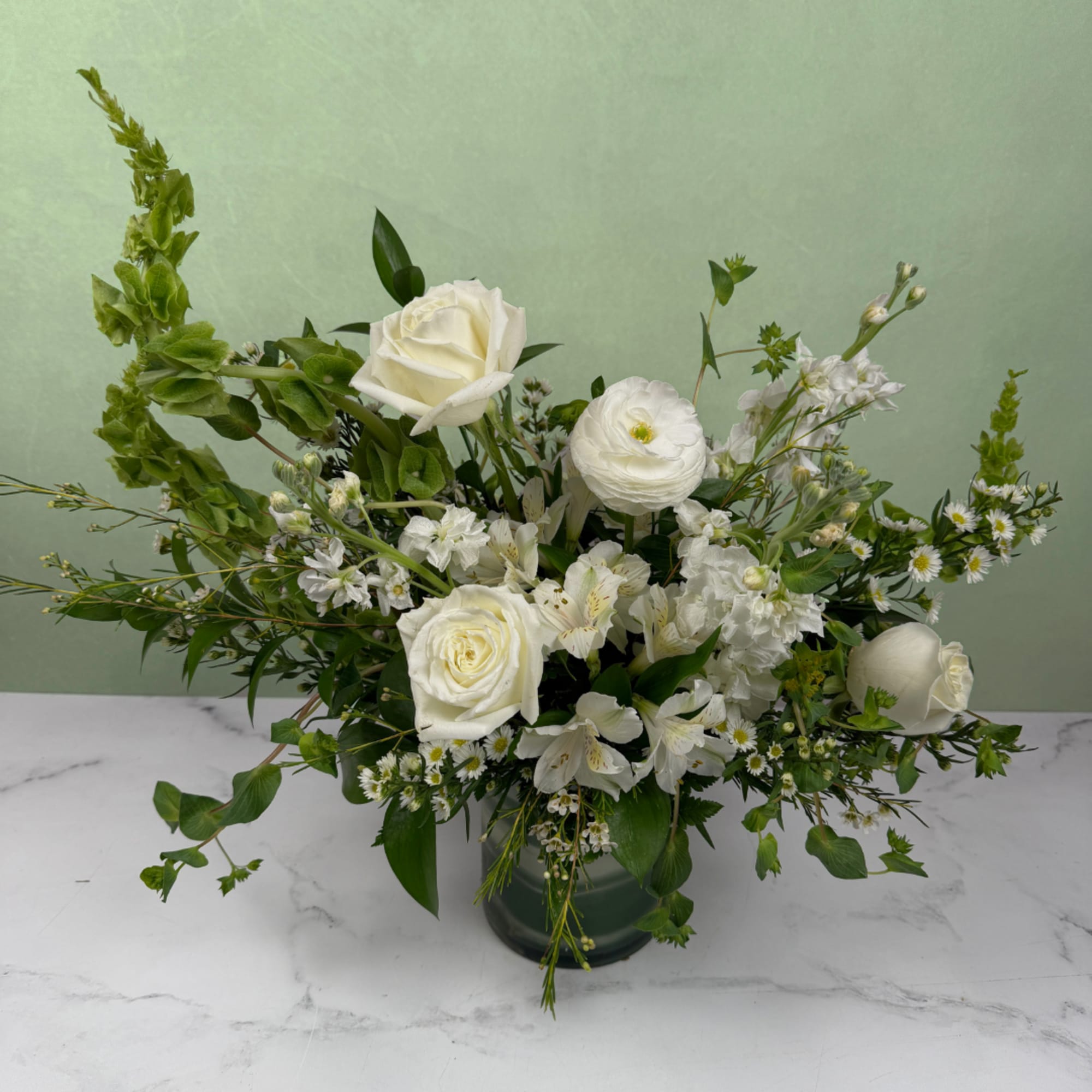 A crisp and elegant mix of white and green blooms designed to