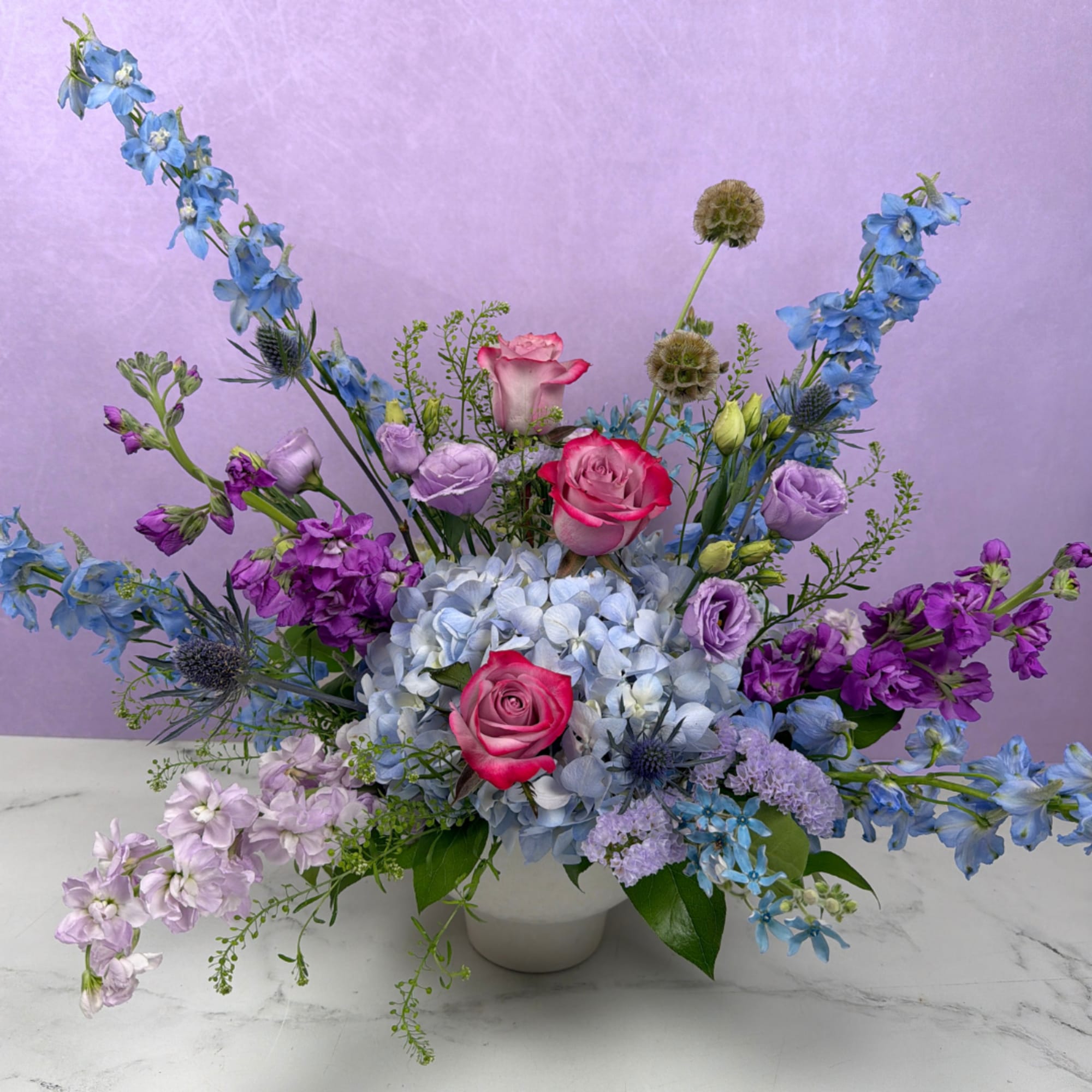 A lush, flowing arrangement of cool-toned blooms designed to feel peaceful and