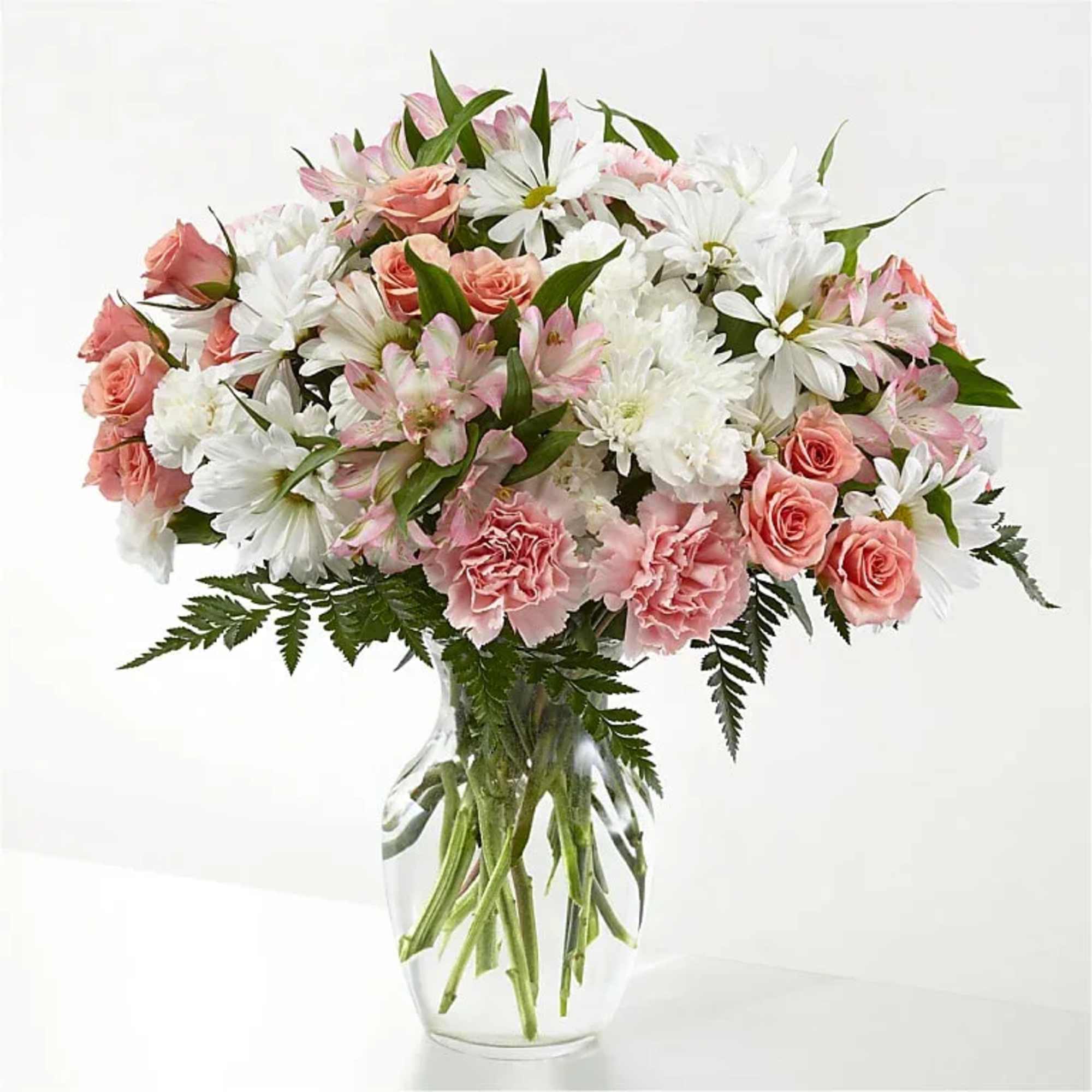 Soft blush roses gather with bright white daisy-like blooms to create an