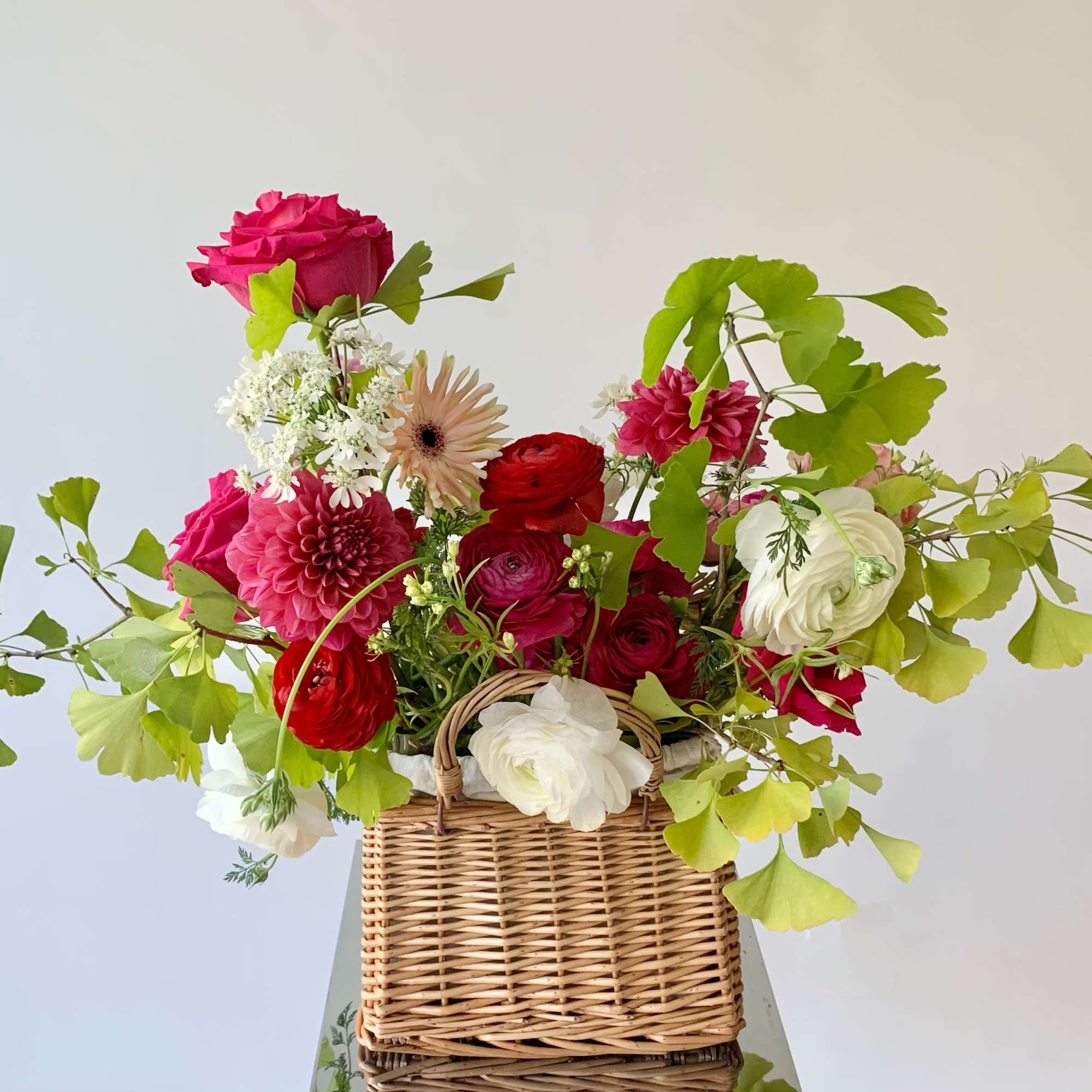 An artfully created arrangement in a rattan woven basket is a perfect