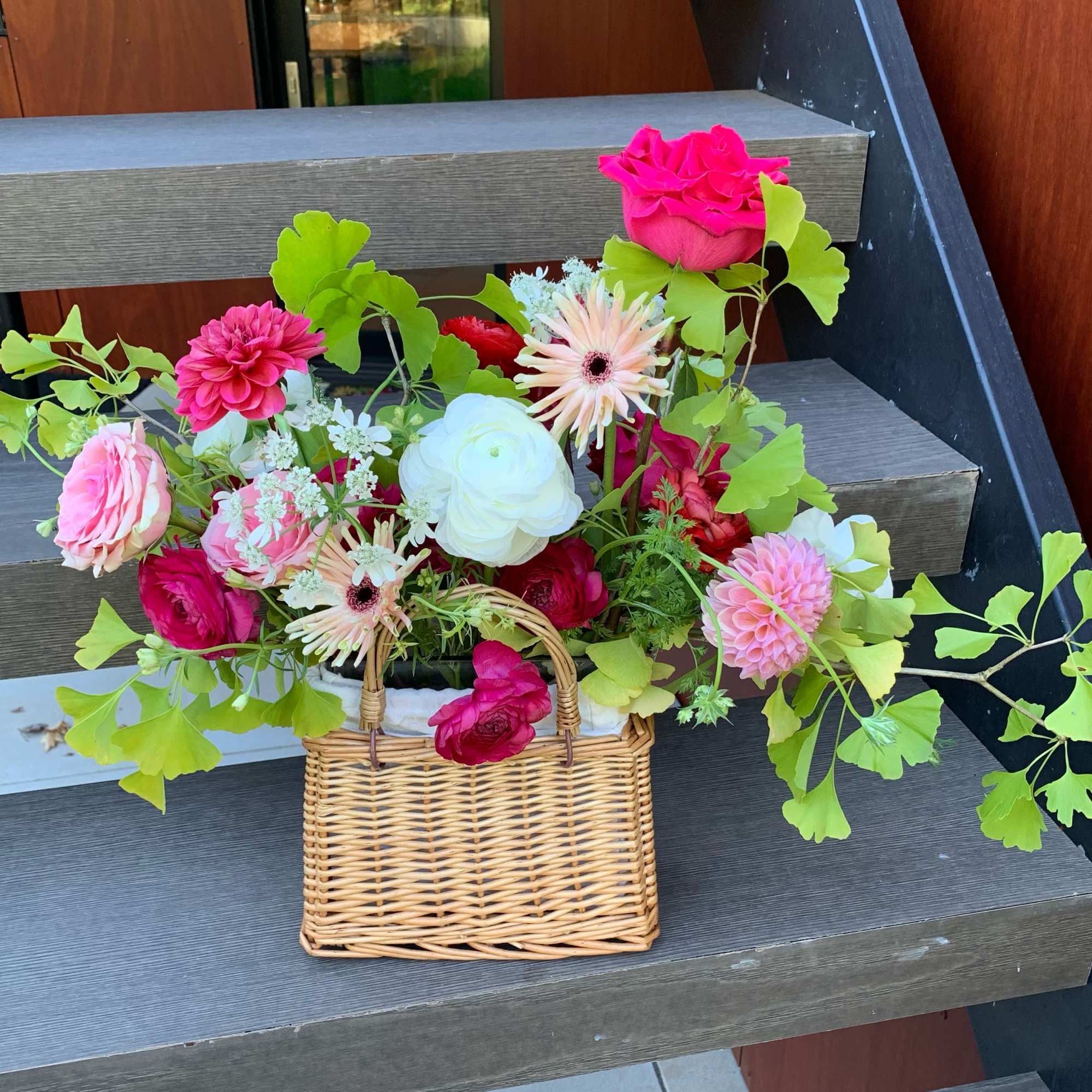 An artfully created arrangement in a rattan woven basket is a perfect