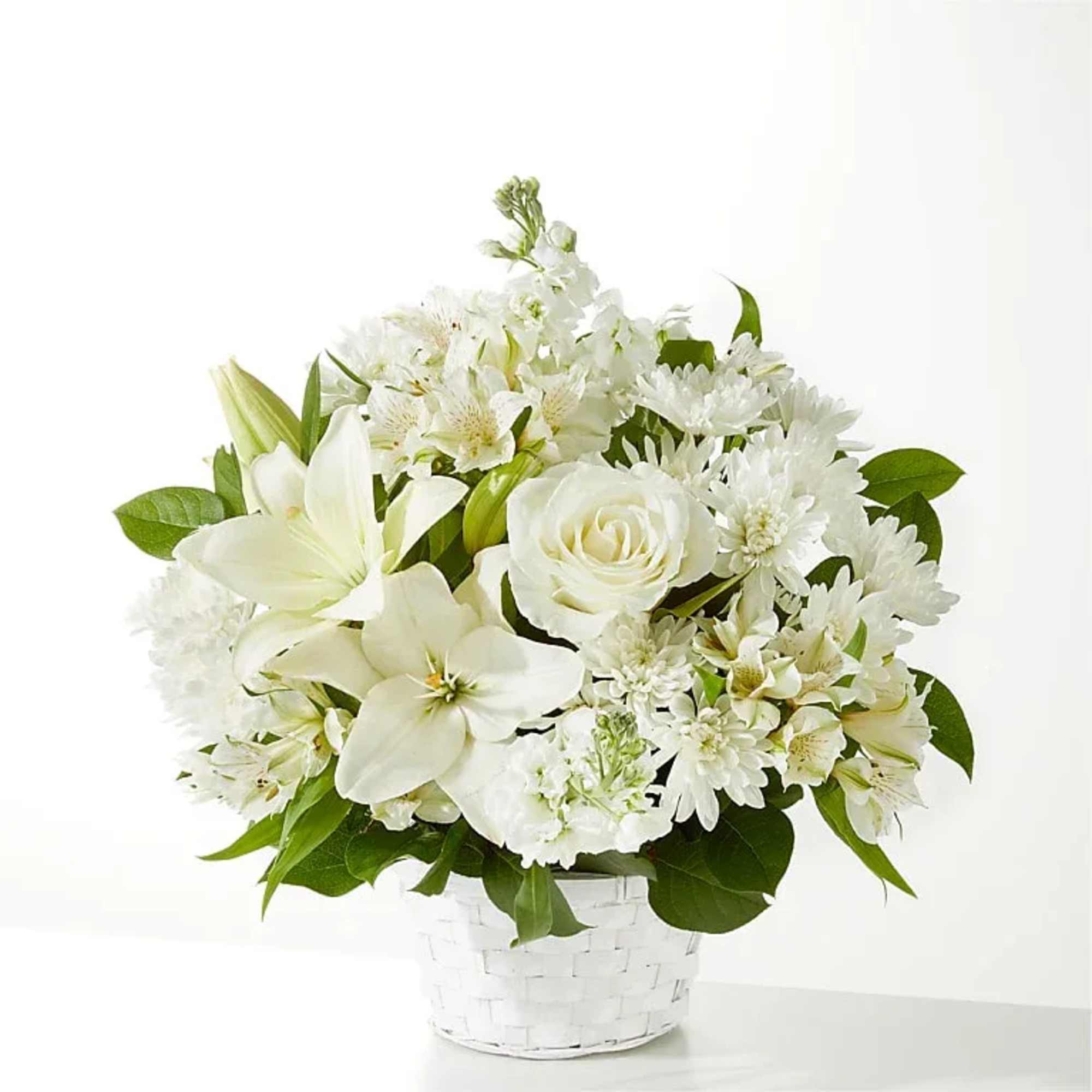 White floral arrangement in a white woven basket