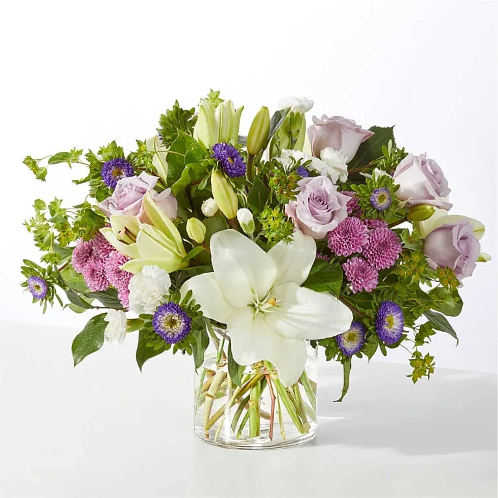 White lilies take center stage in this airy garden-style vase arrangement, a