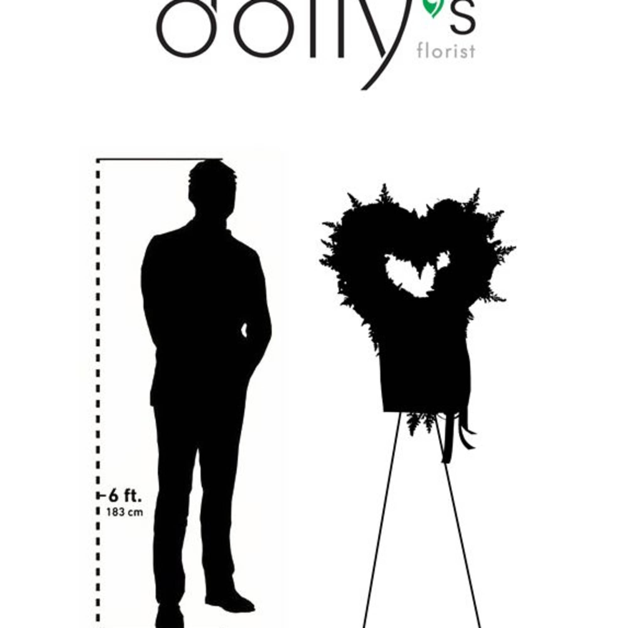Tall heart-shaped floral standing spray on an easel beside a height silhouette
