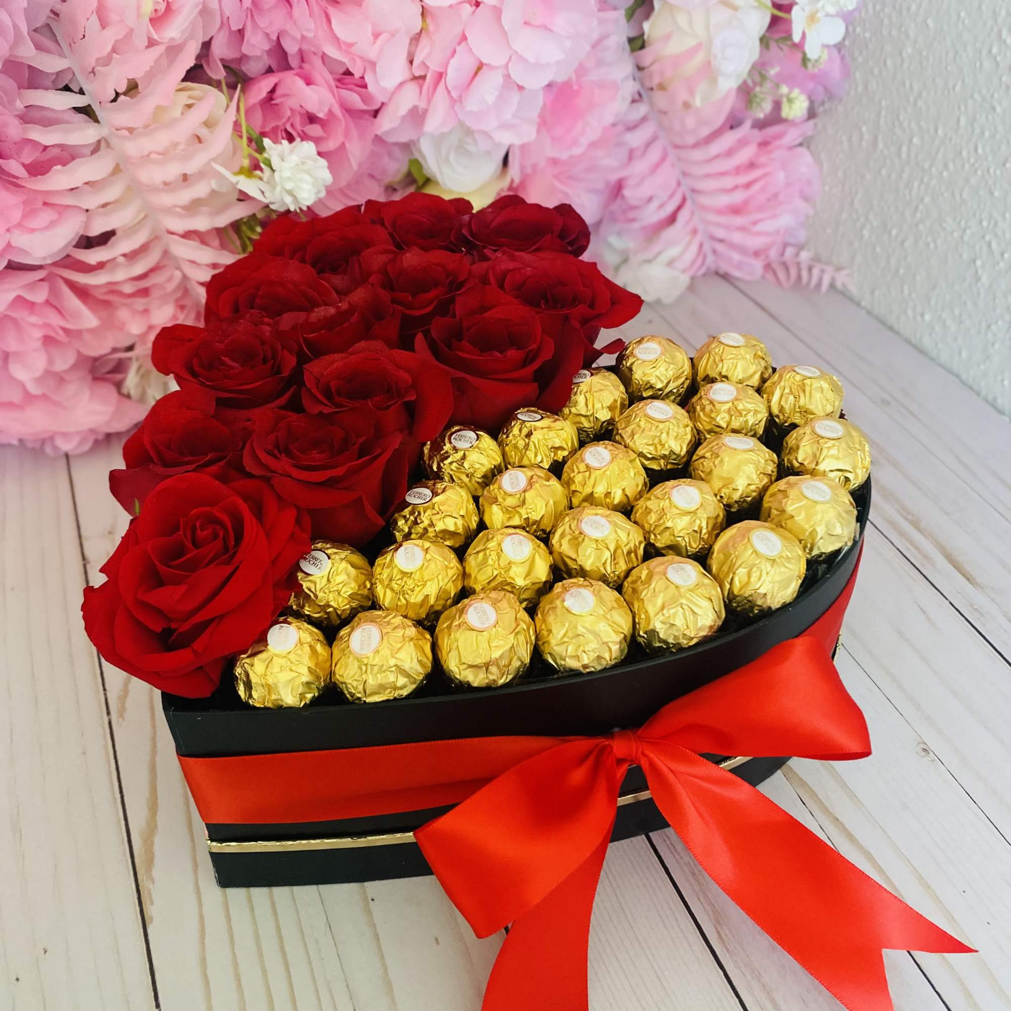 Heart-shaped box with red roses and gold-wrapped chocolates