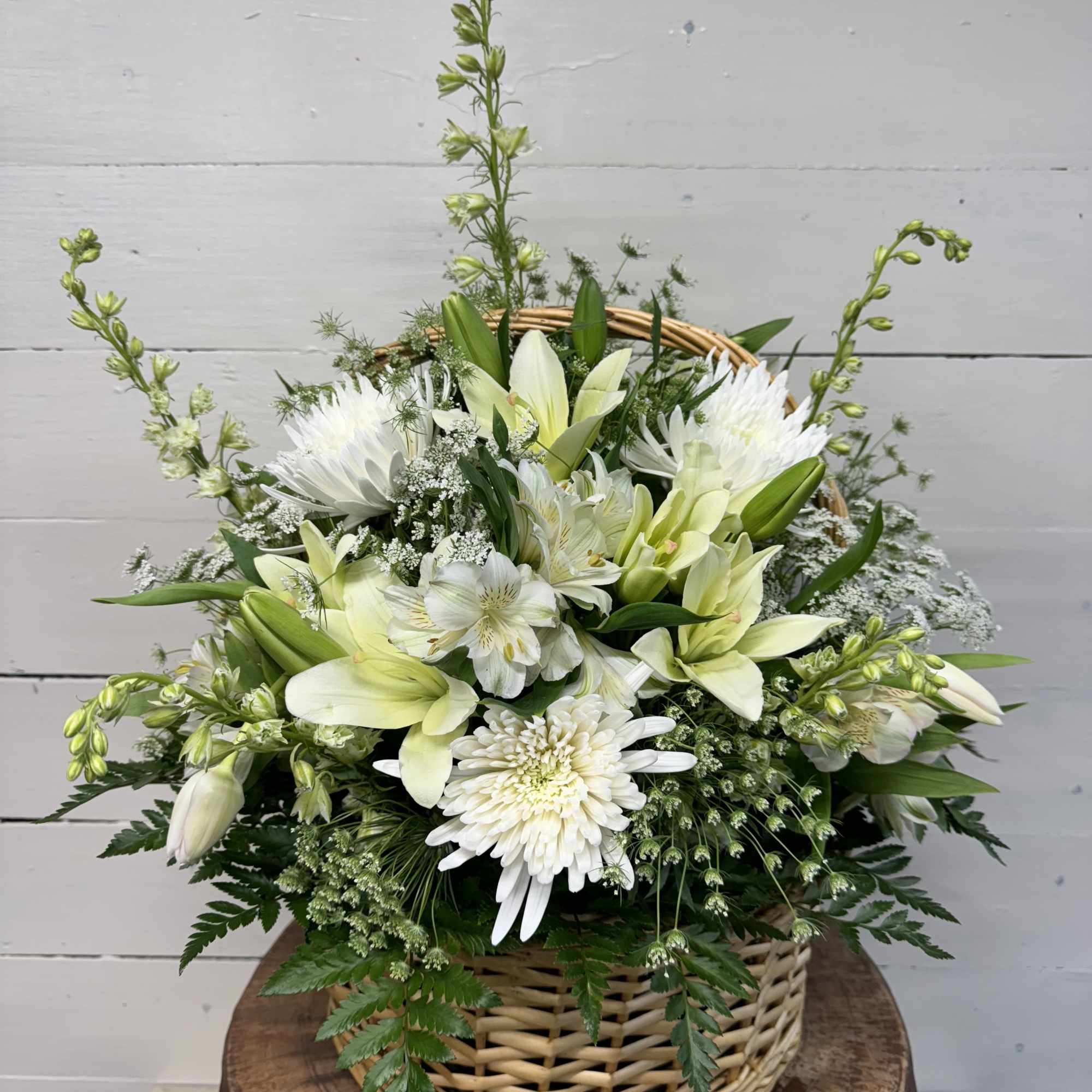 White floral basket arrangement with lilies and chrysanthemums