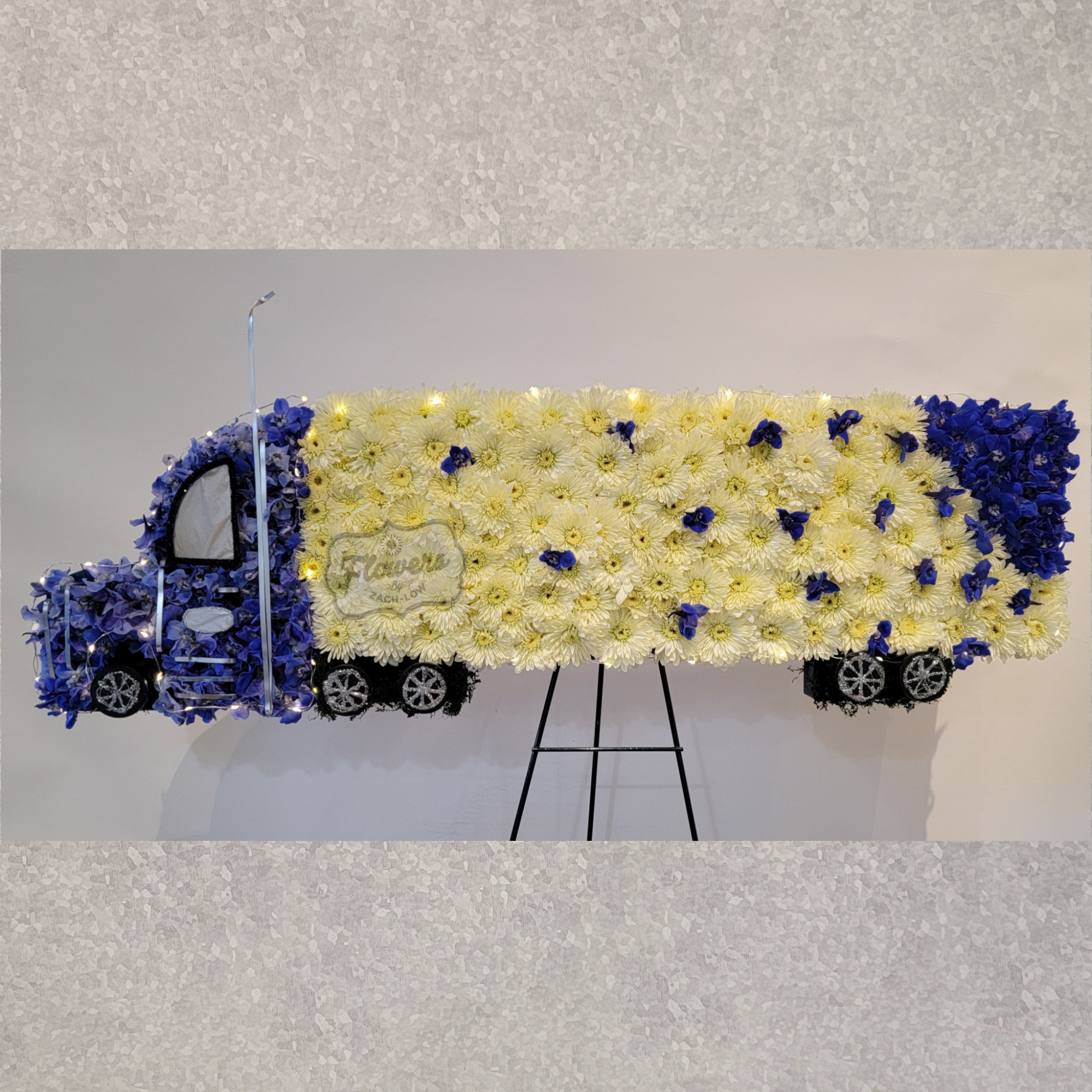 Flower-covered truck display with yellow and blue blooms