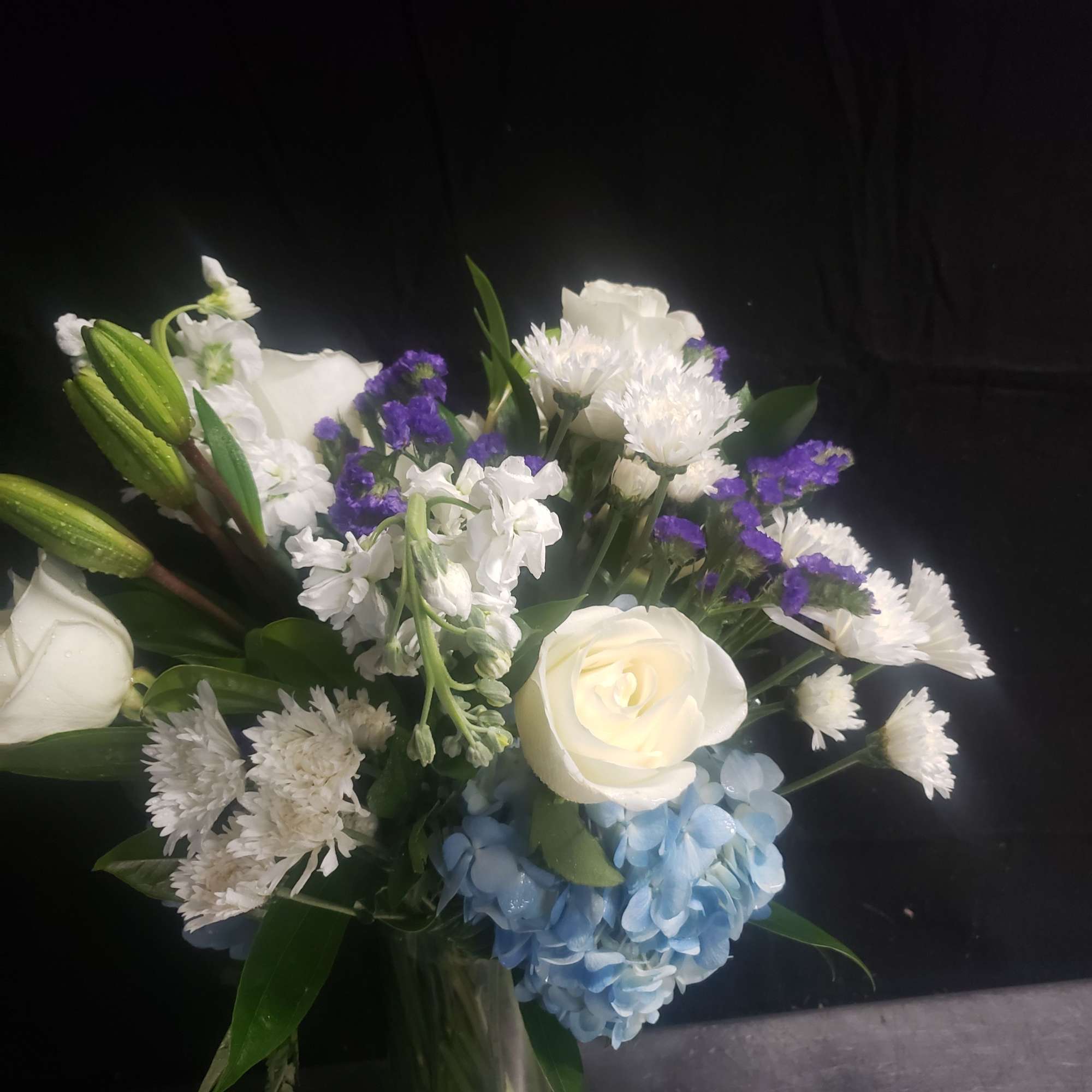 A serene bouquet centered on a large blue hydrangea gives this white-and-blue