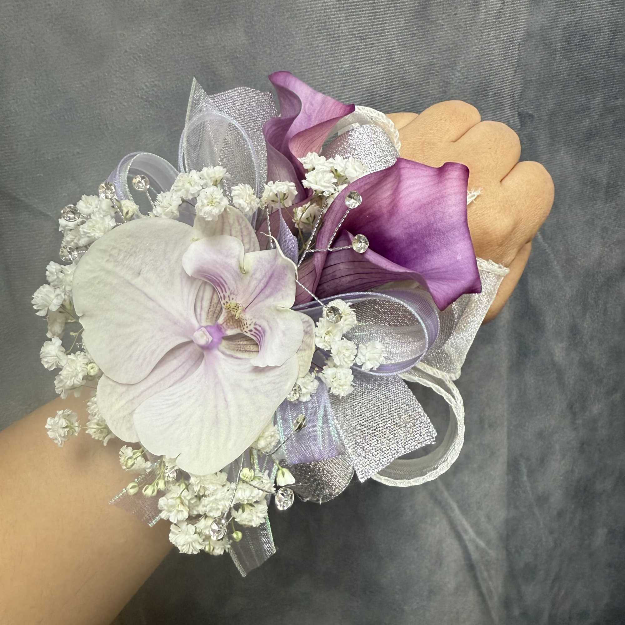 Purple calla lilies and lavender orchids, rhinestone picks and layered ribbons-an elegant