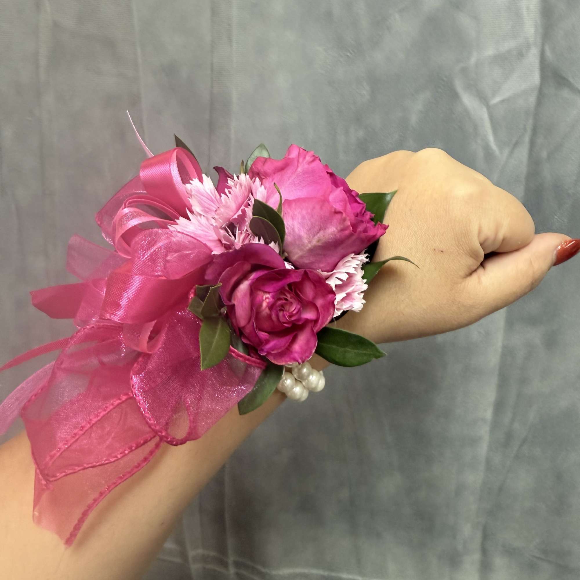 Bright hot-pink roses with pink carnations, accented with organza and a glossy
