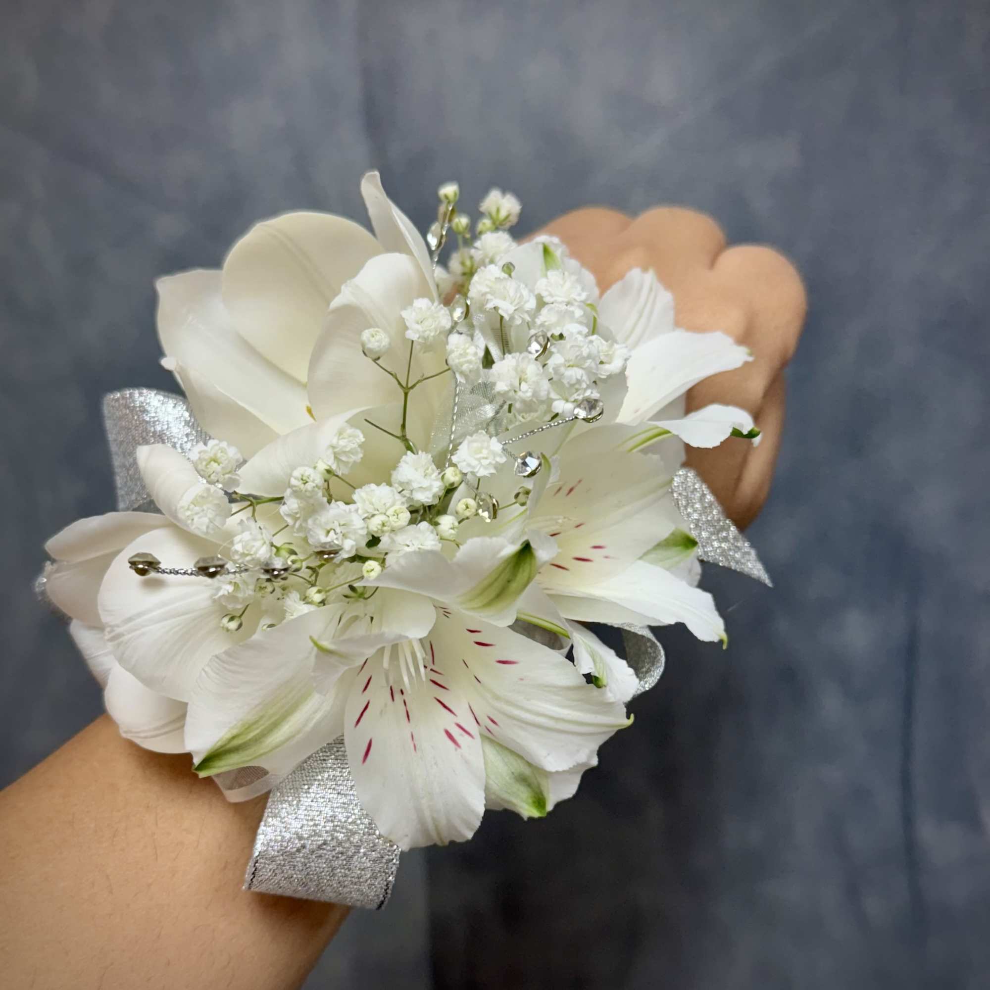 White alstroemeria and tulip wrist corsage with silver ribbon, glitter and pearl