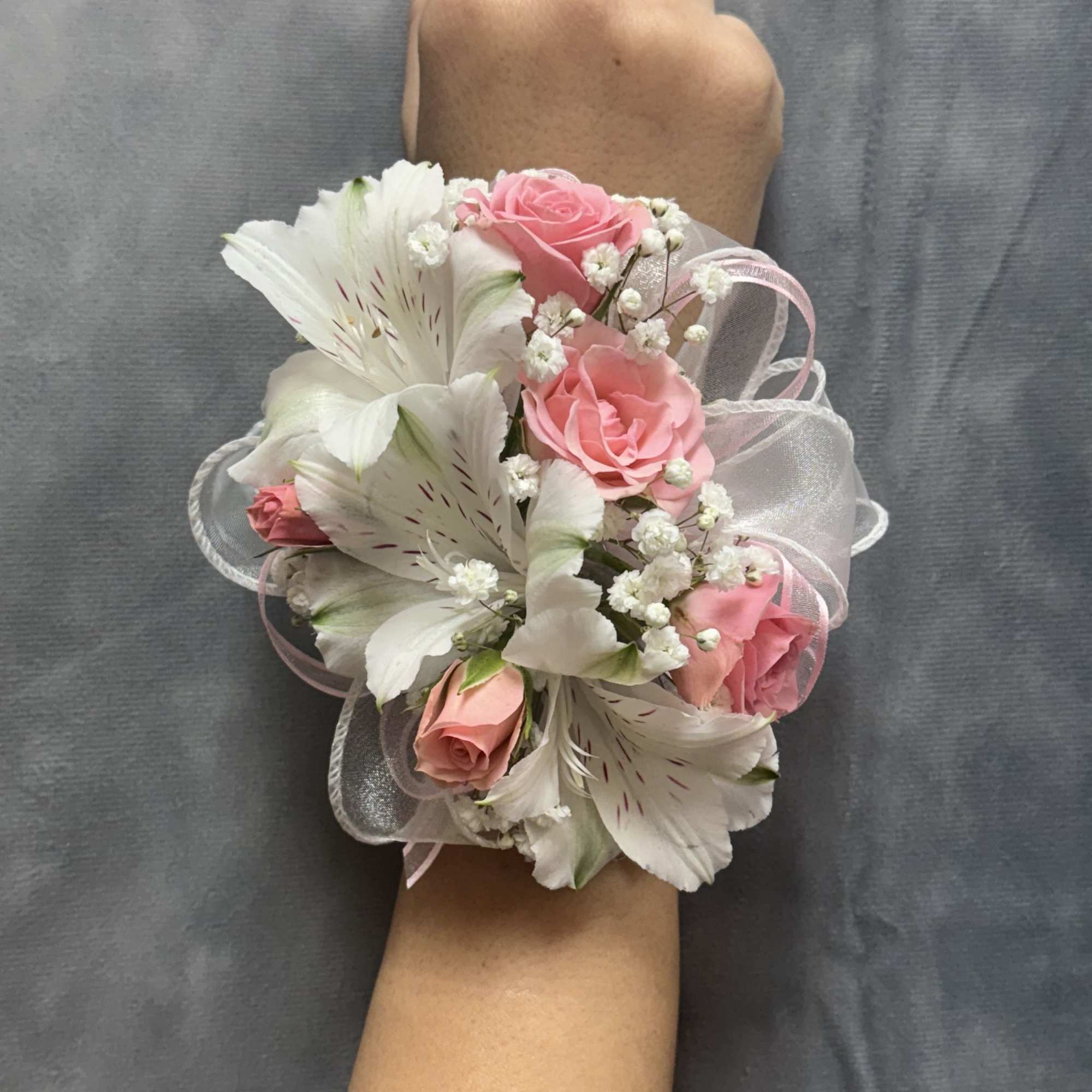 Pink spray roses and white alstroemeria with delicate filler and sheer ribbon