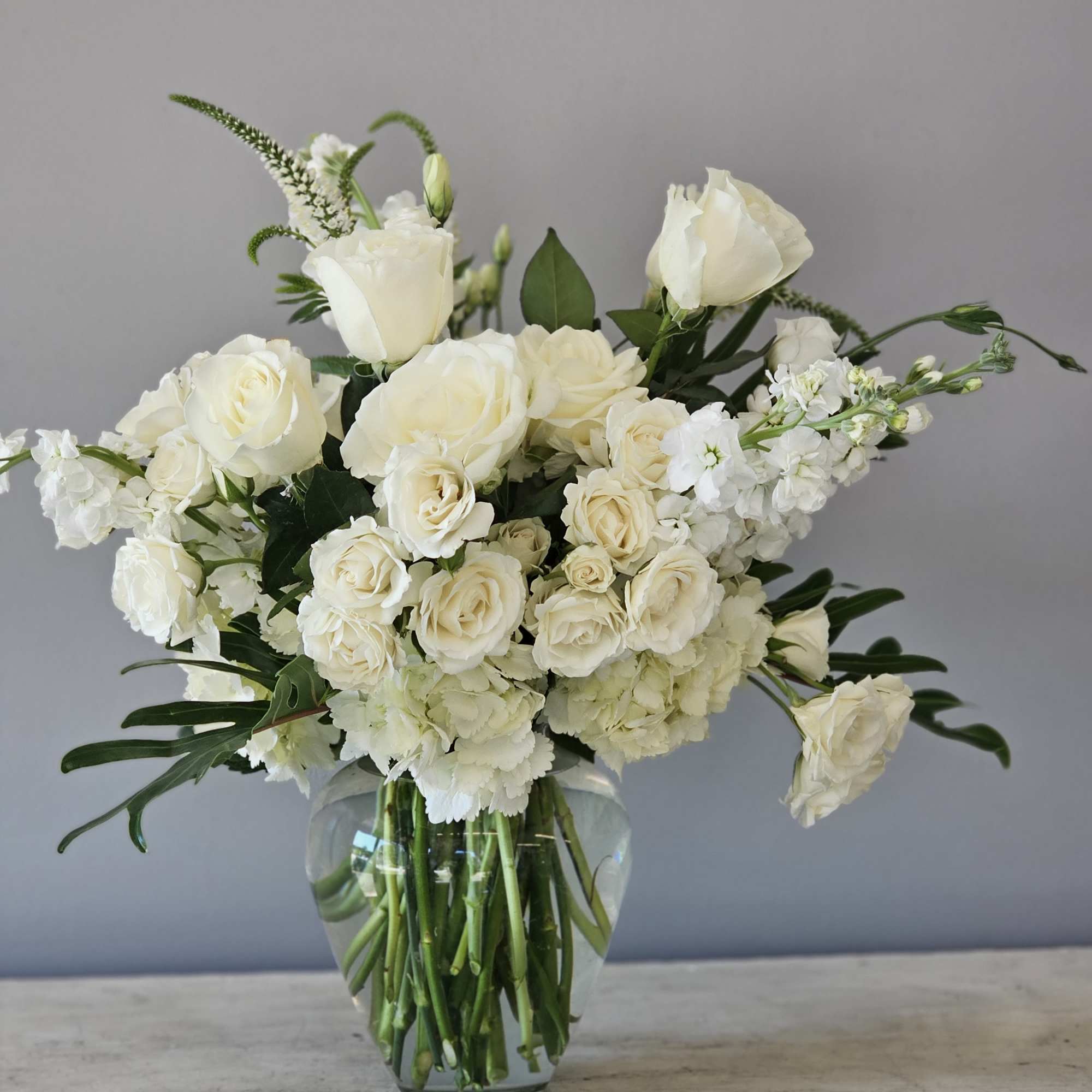 Beautiful modern vase of all white flowers including roses