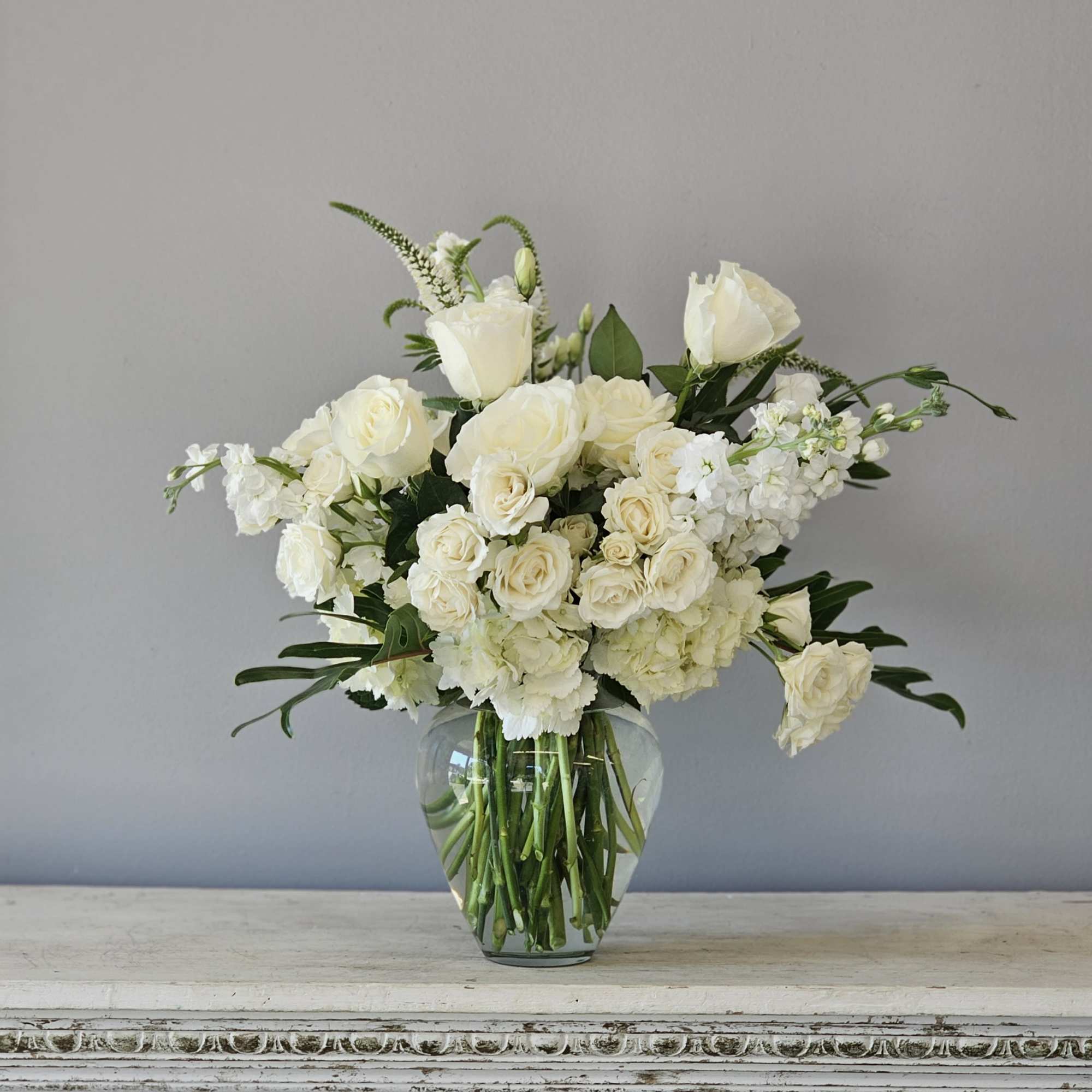 Beautiful modern vase of all white flowers including roses