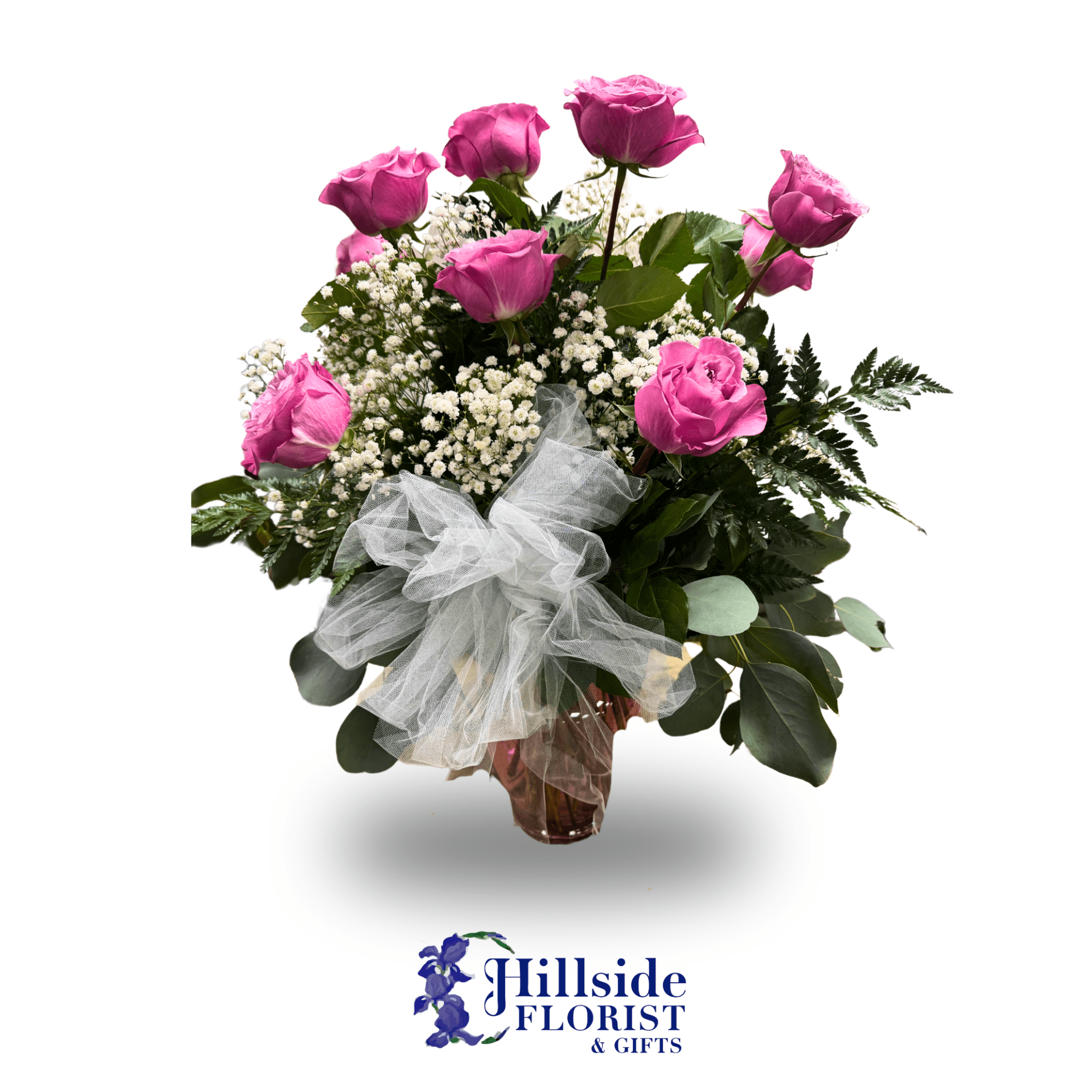 Pink roses in a glass vase with baby's breath and a white tulle bow
