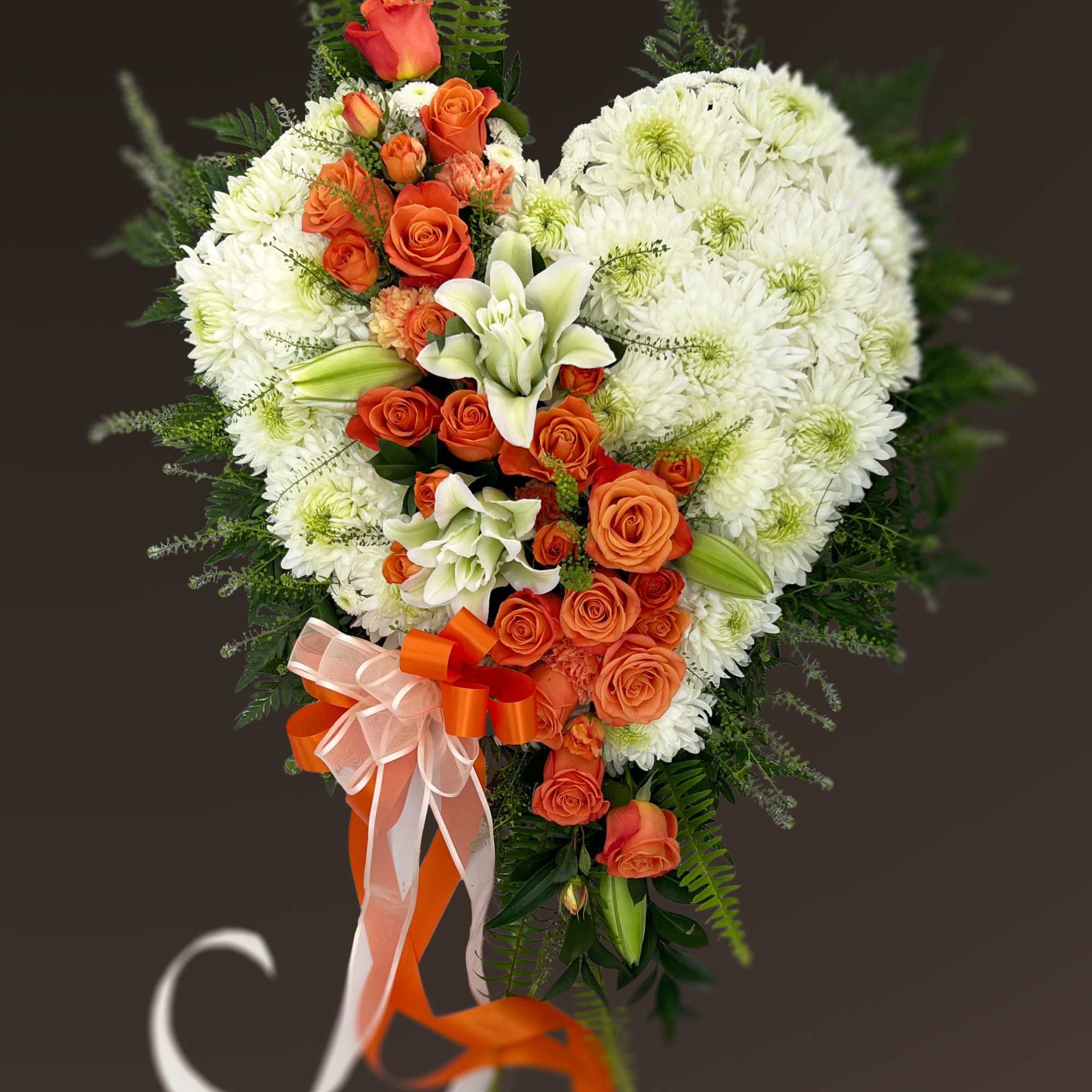 Heart-shaped bouquet of orange roses and white chrysanthemums with ribbon