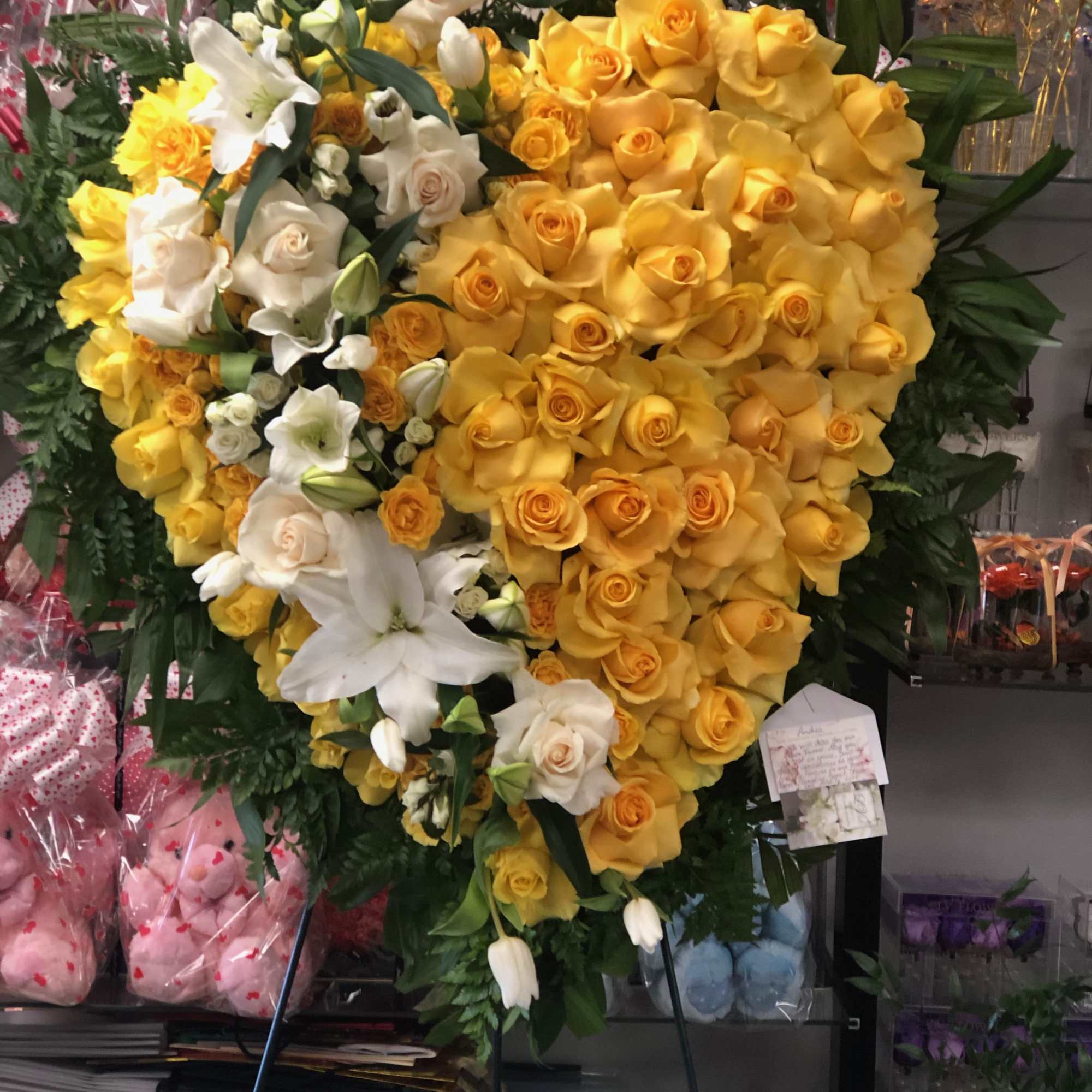 Heart-shaped yellow and white rose arrangement on an easel