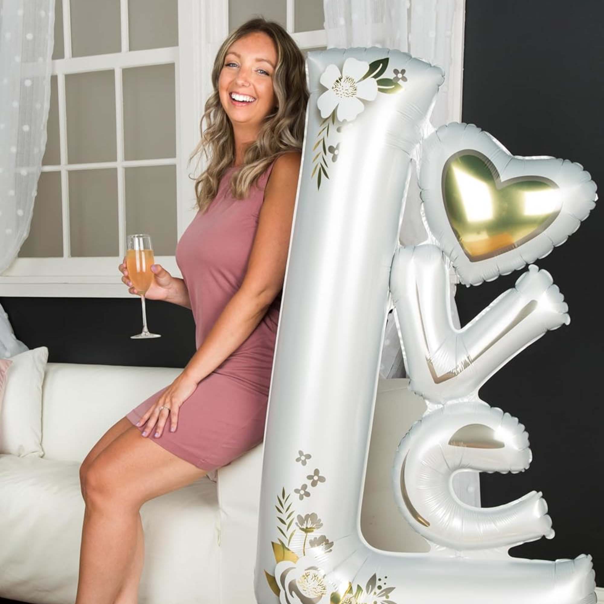 This free-standing "Love" balloon decoration features precious flower details and a base