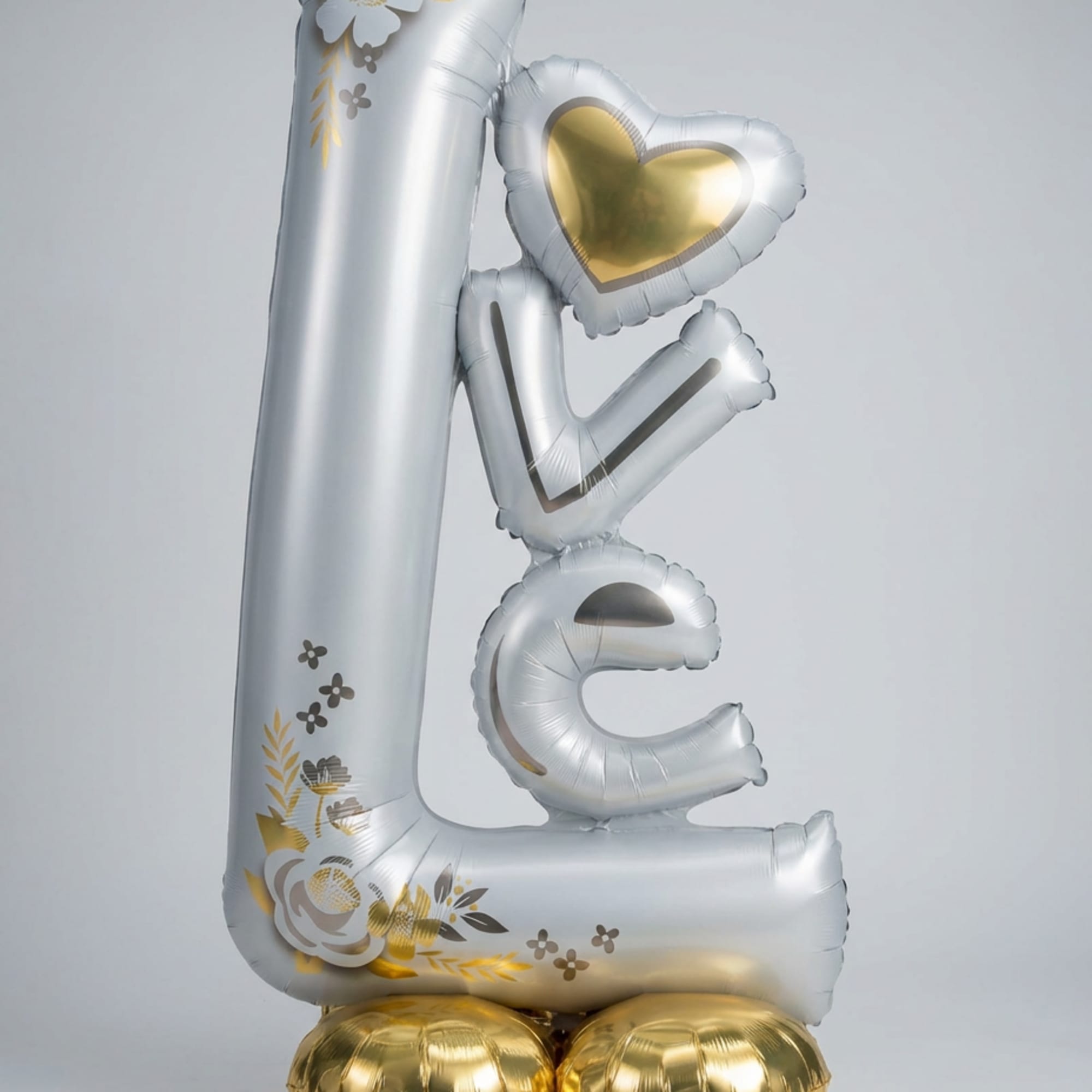 This free-standing "Love" balloon decoration features precious flower details and a base