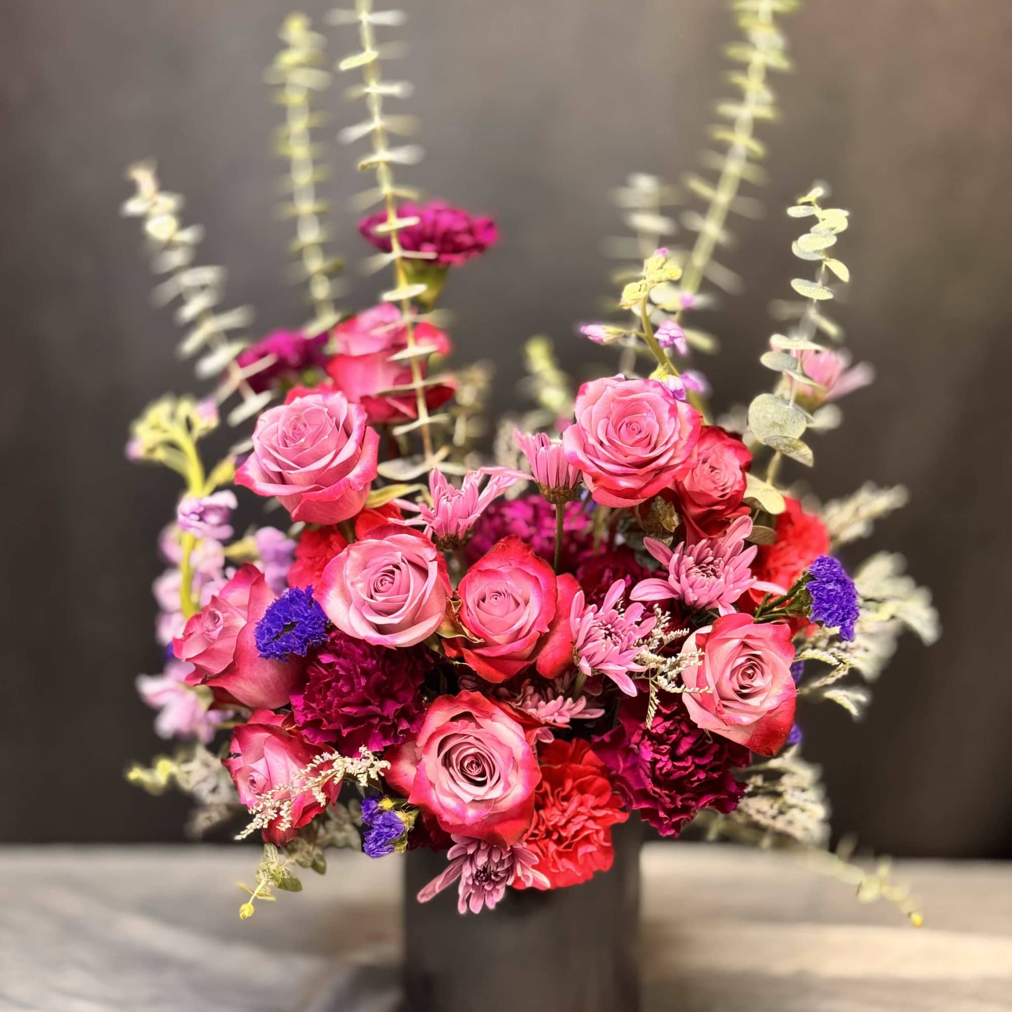 Pink rose bouquet in a black cylindrical vase