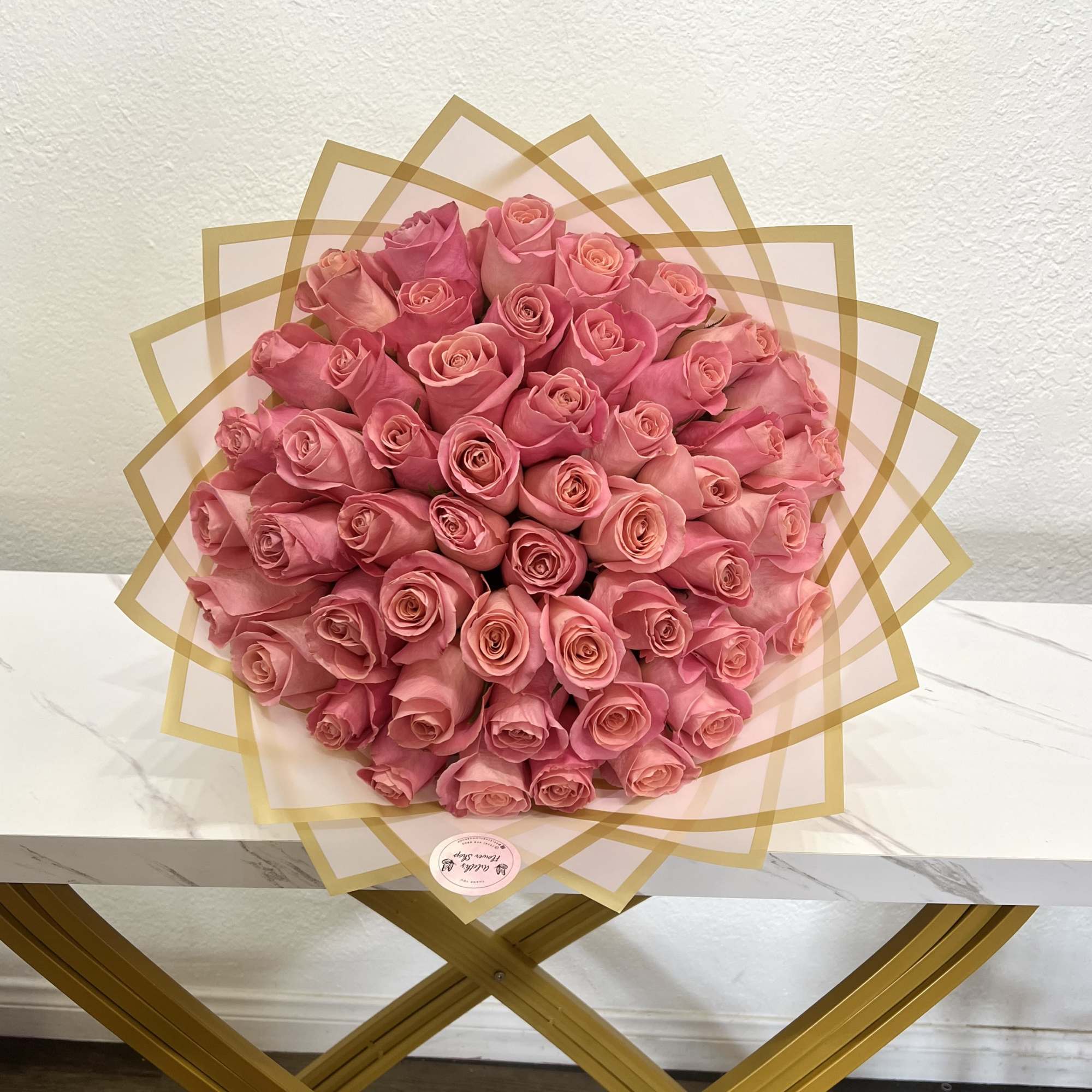Large bouquet of pink roses wrapped in translucent paper