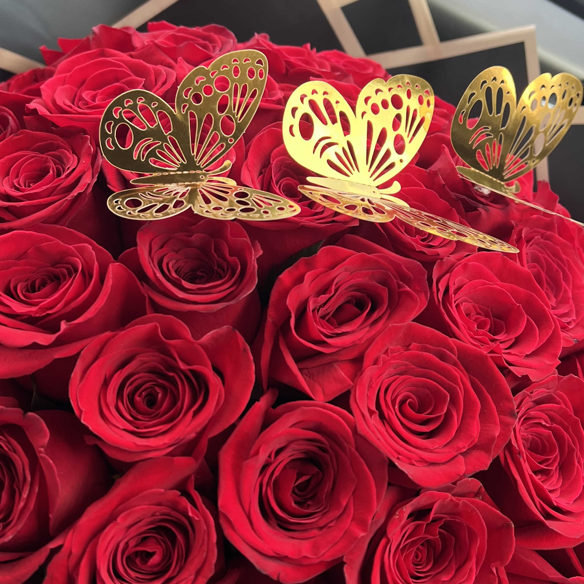 Bouquet of red roses with gold butterfly decorations