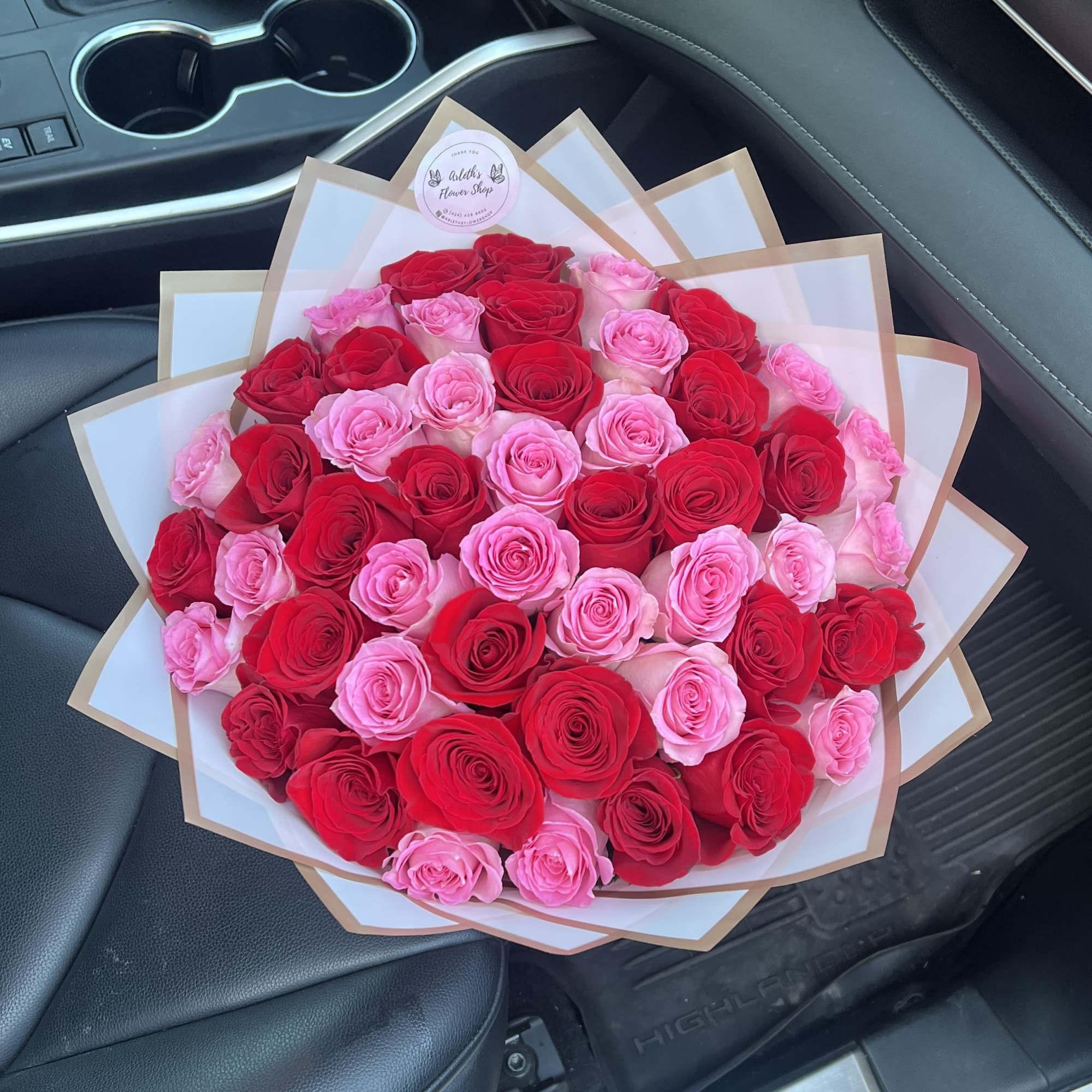 Bouquet of red and pink roses wrapped in white paper