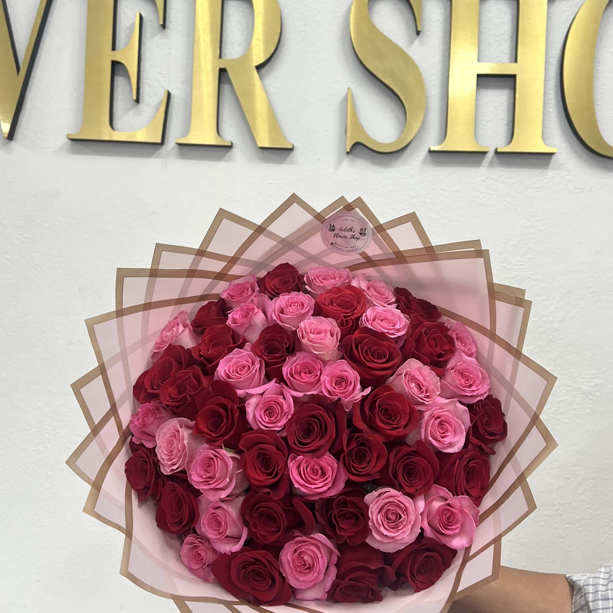 Large bouquet of pink and red roses wrapped in pink paper