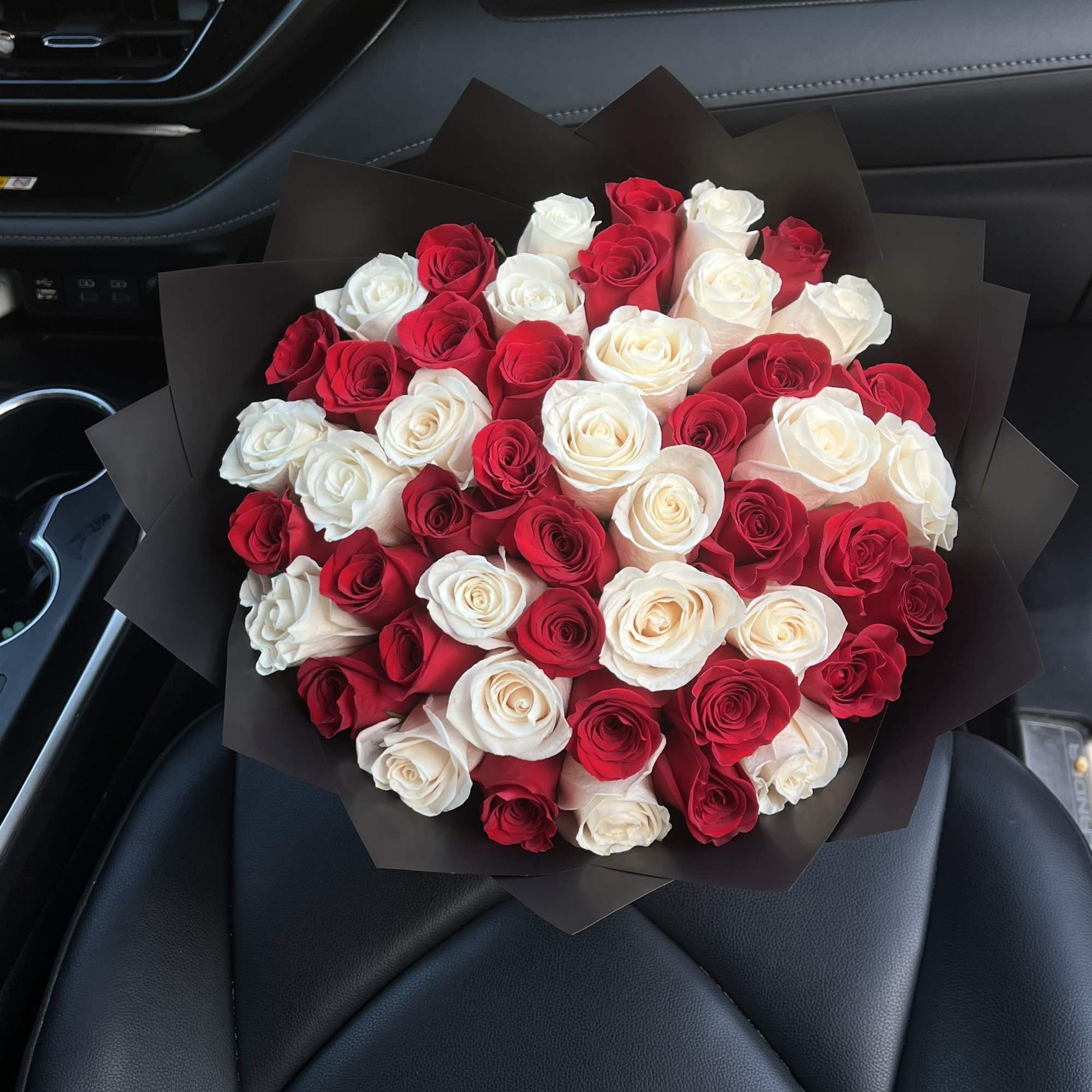 Bouquet of red and white roses wrapped in black paper