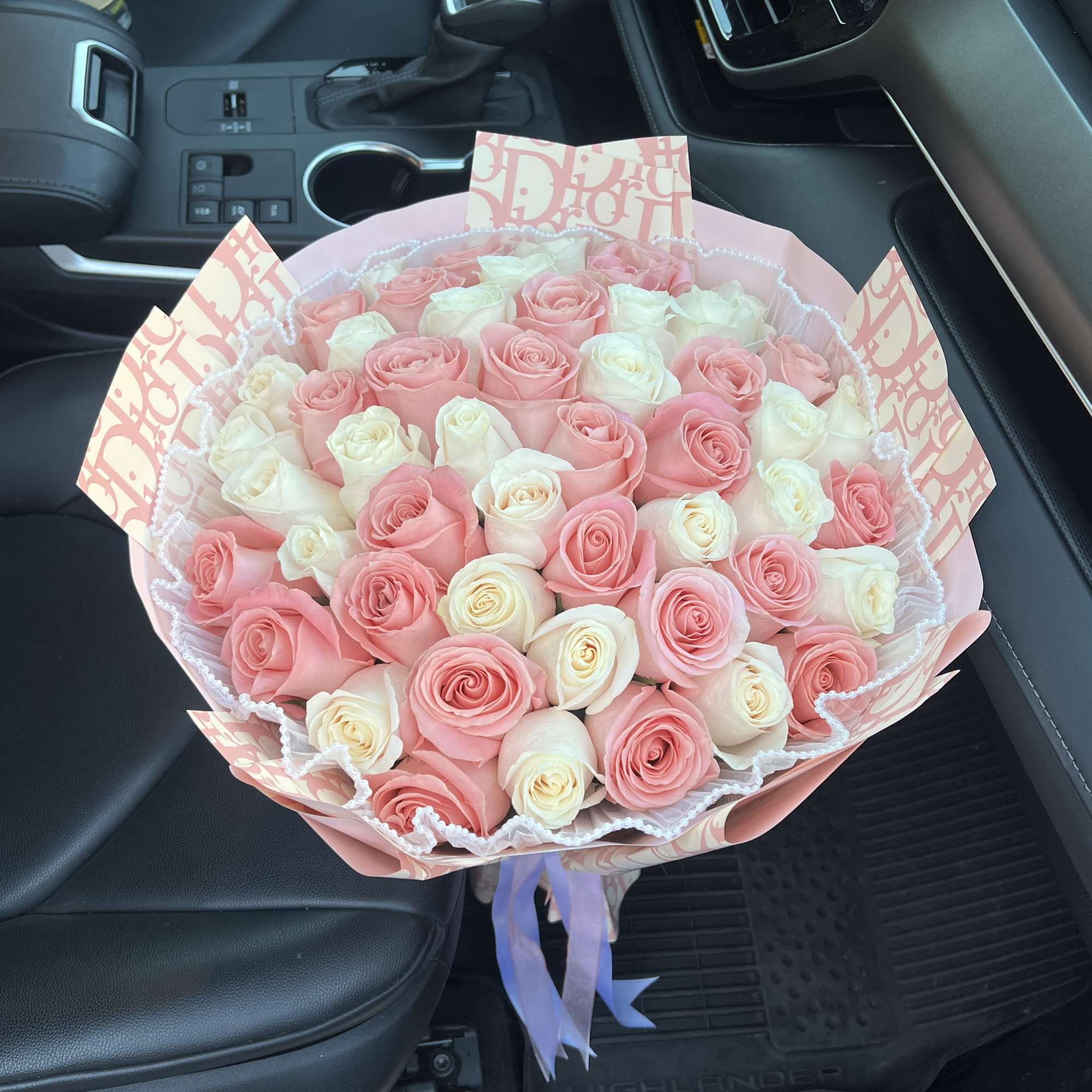Bouquet of pink and white roses wrapped in pink paper