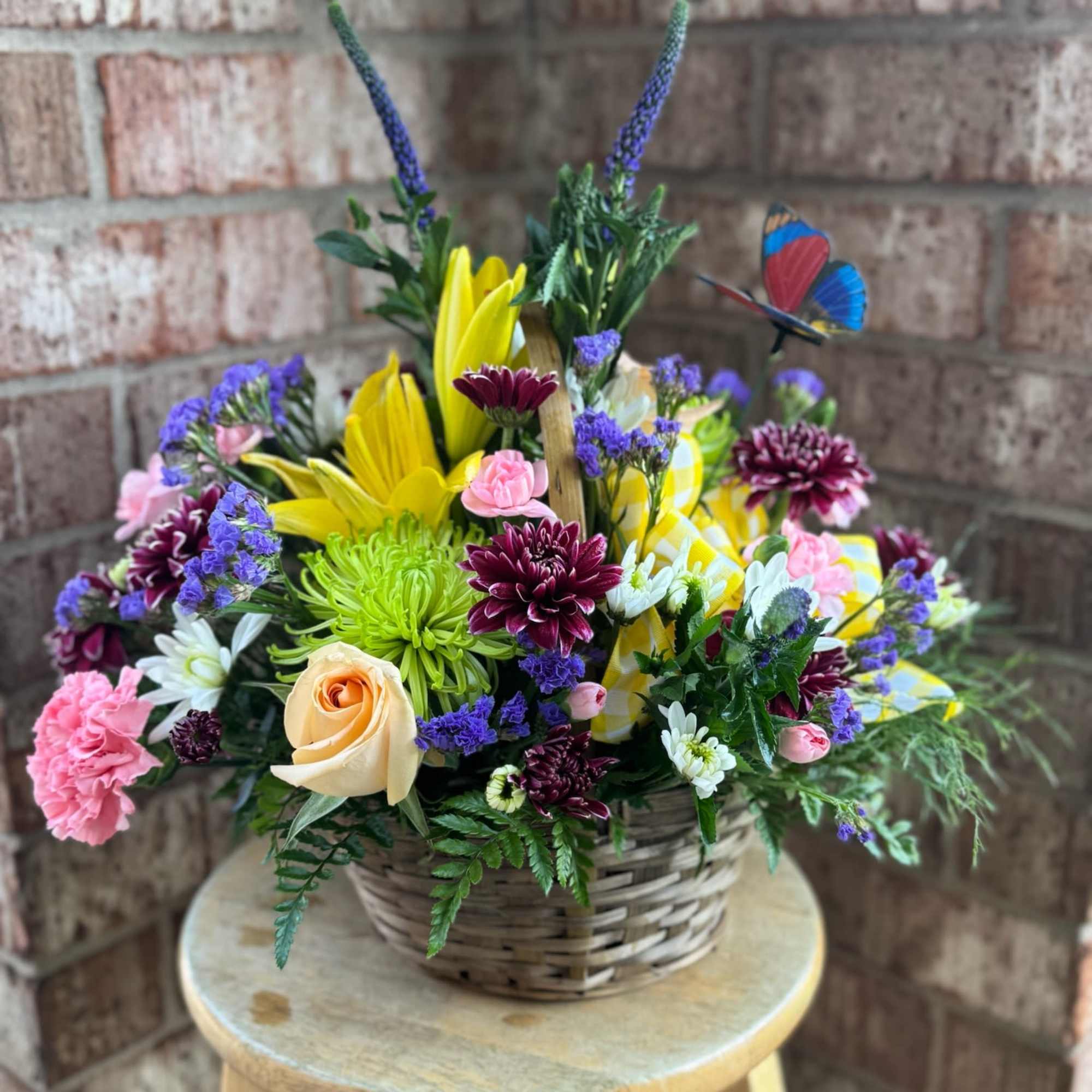 Mixed flower basket with roses, daisies, and lilies in a wicker container
