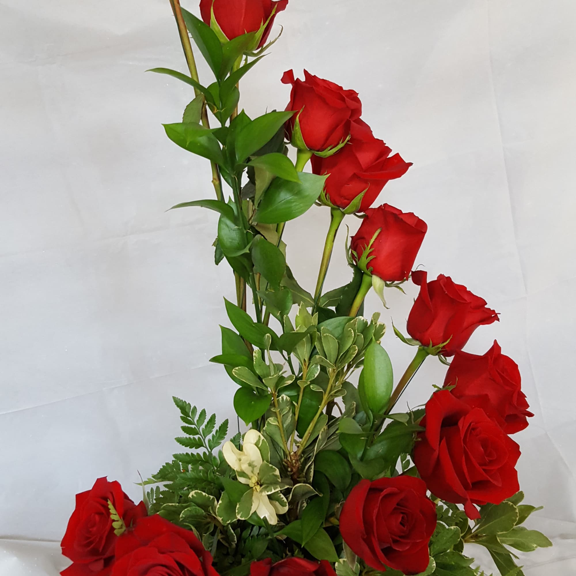 Tall arrangement of red roses with mixed greenery